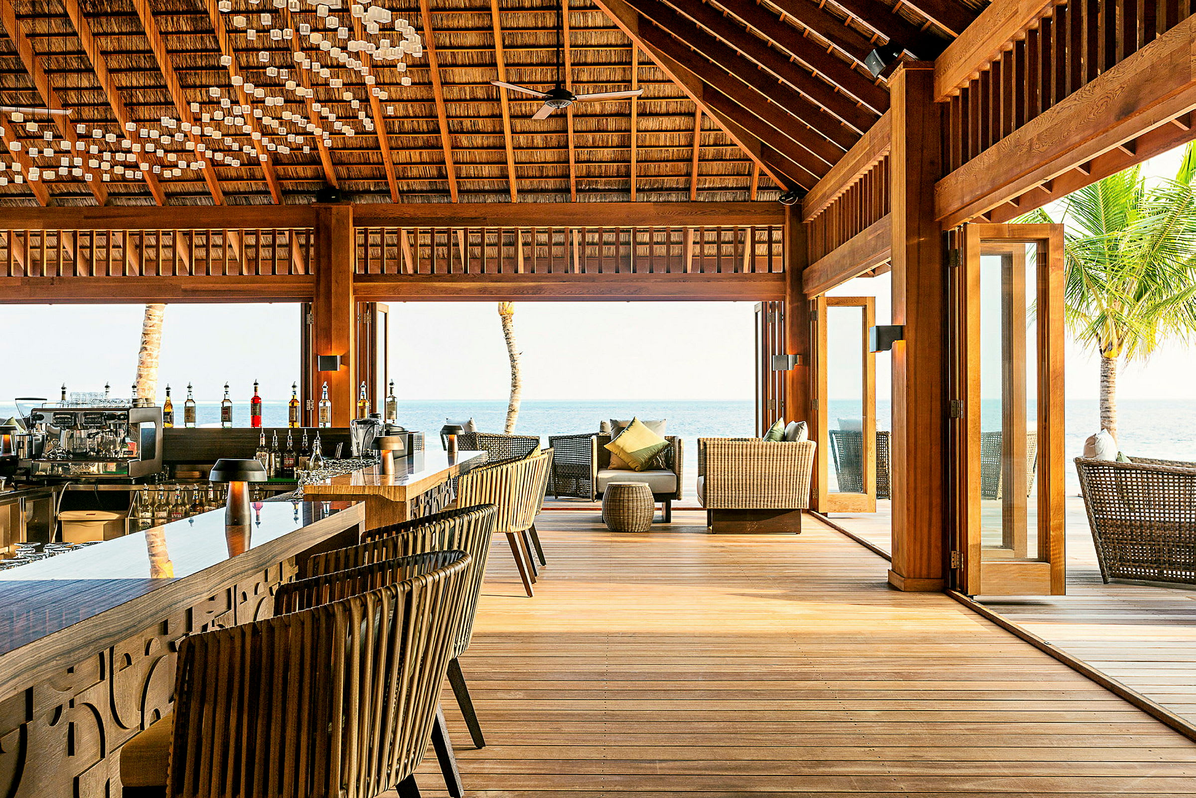 En utomhusbar och lounge med träinredning nära havet. (AI-genererad text)