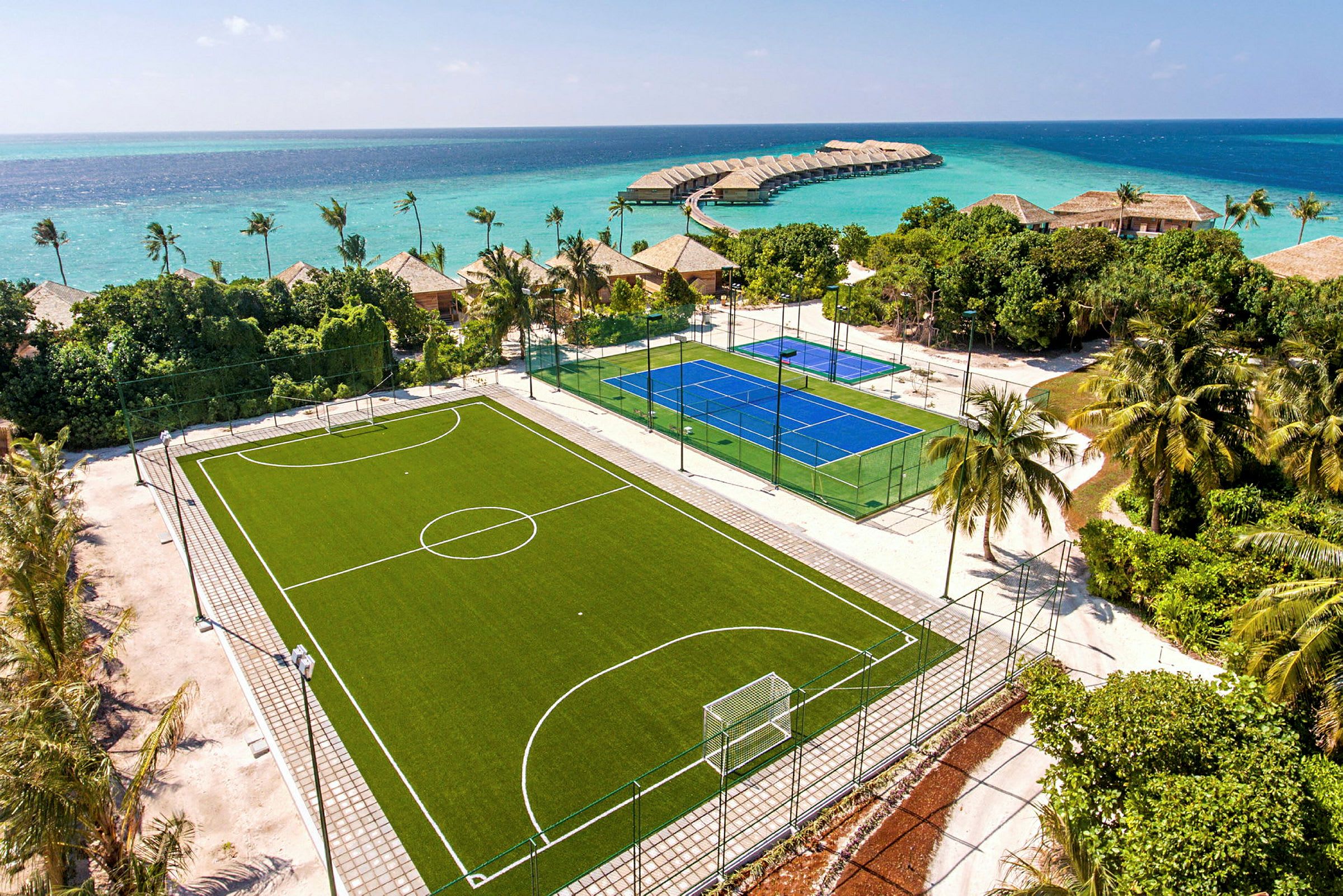 En fotbollsplan och en tennisplan nära stranden. (AI-genererad text)