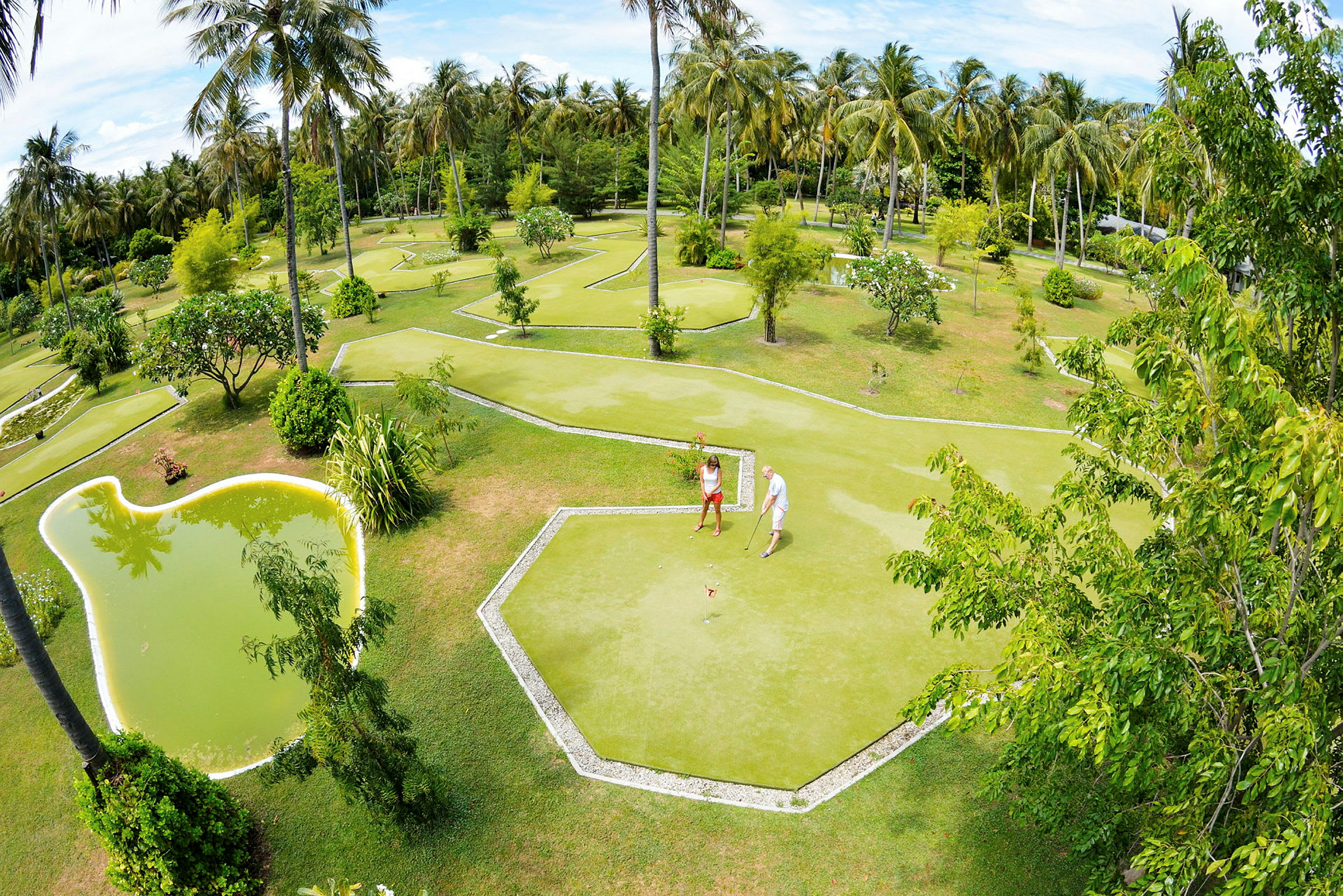 Två personer spelar minigolf i en tropisk trädgård med palmer. (AI-genererad text)