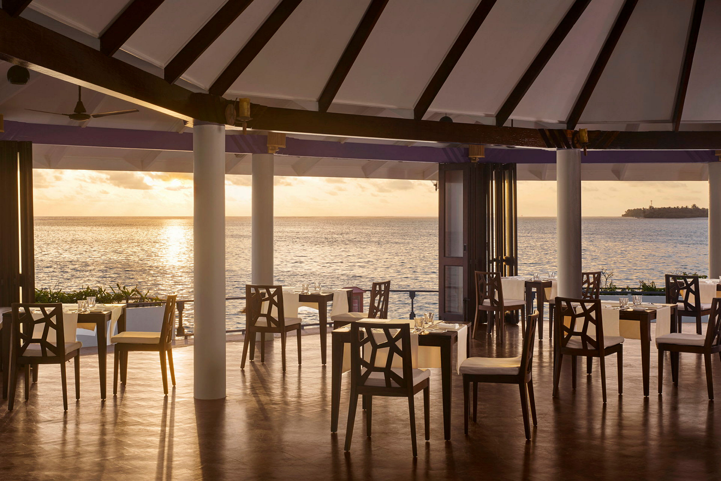 En restaurang med utsikt över havet vid solnedgången. (AI-genererad text)
