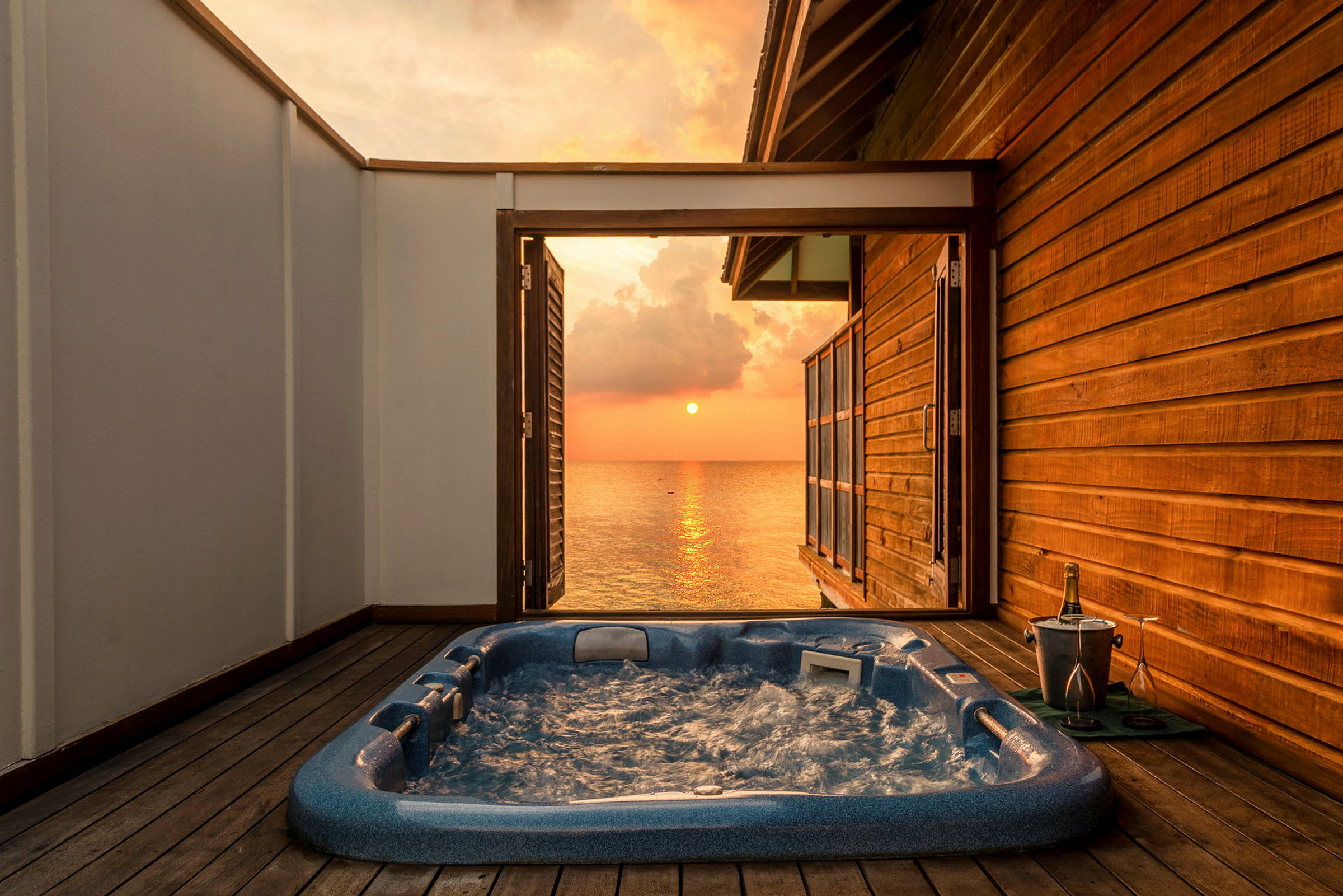 Utomhusjacuzzi på terrass med utsikt över solnedgången. (AI-genererad text)