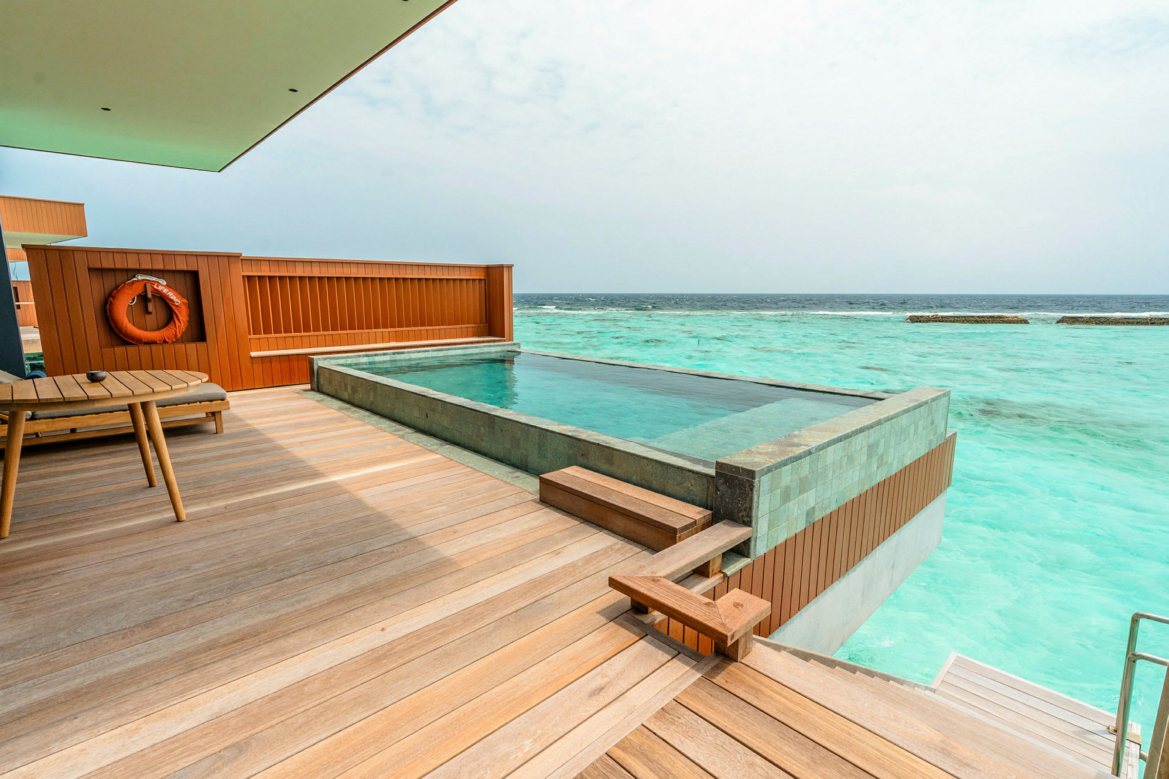 Bild av en terrass med en privat pool, havet synligt i bakgrunden. (AI-genererad text)