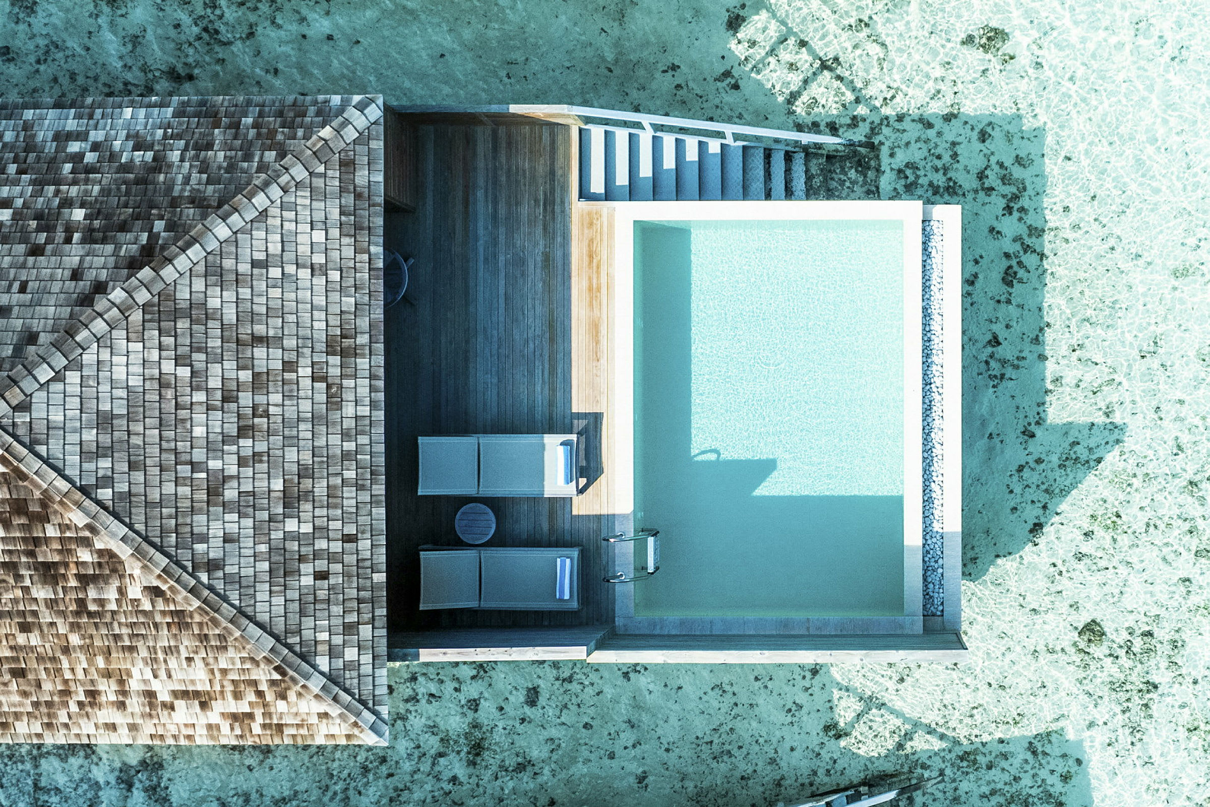 Flygfoto av en lyxvilla med privat pool och utsikt över klart vatten. (AI-genererad text)