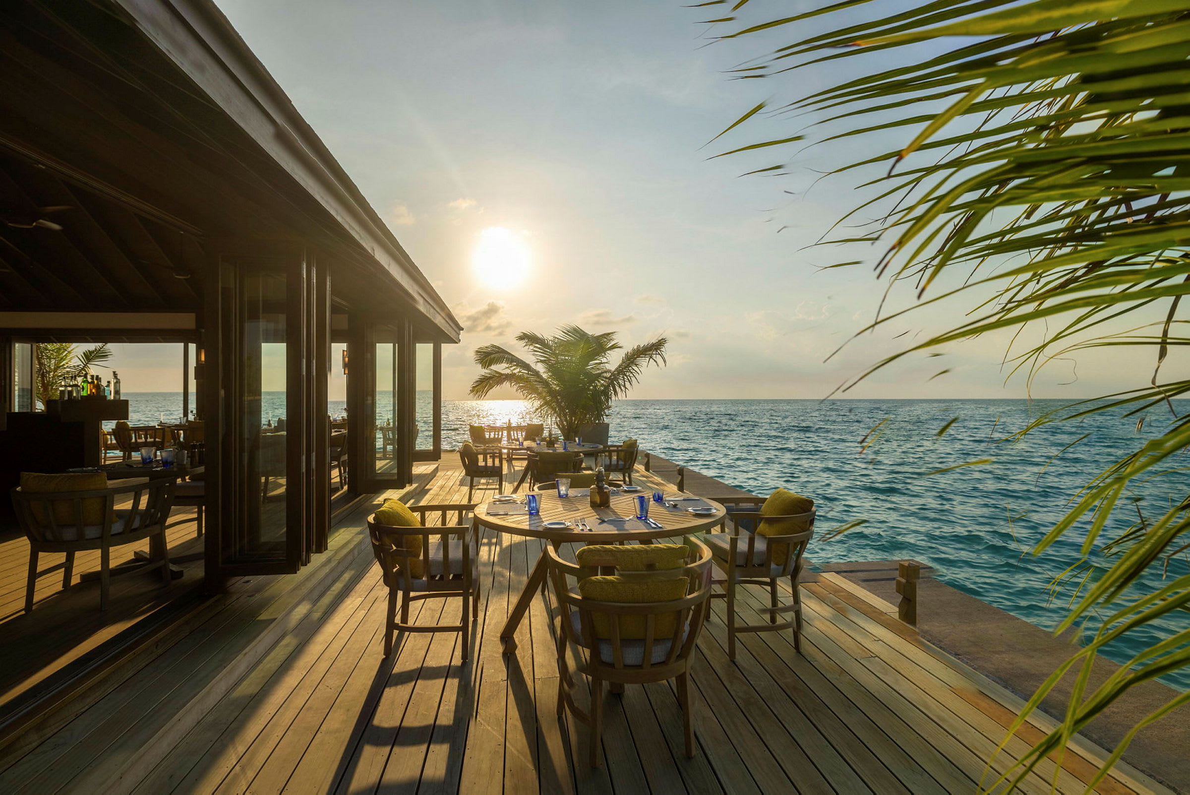 Restaurang vid havet med utsikt över solnedgången. (AI-genererad text)
