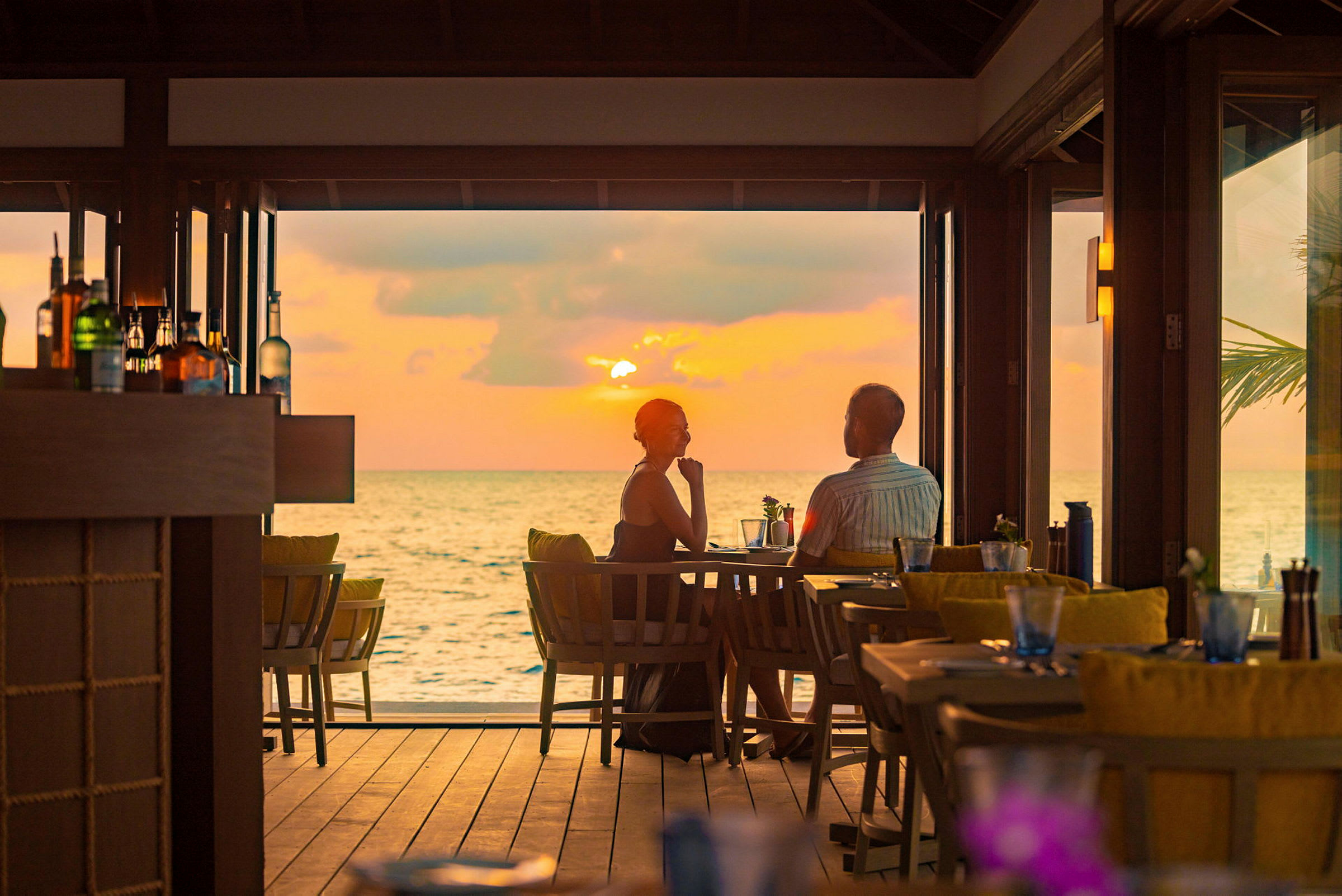 En restaurang vid havet med utsikt över solnedgången. (AI-genererad text)