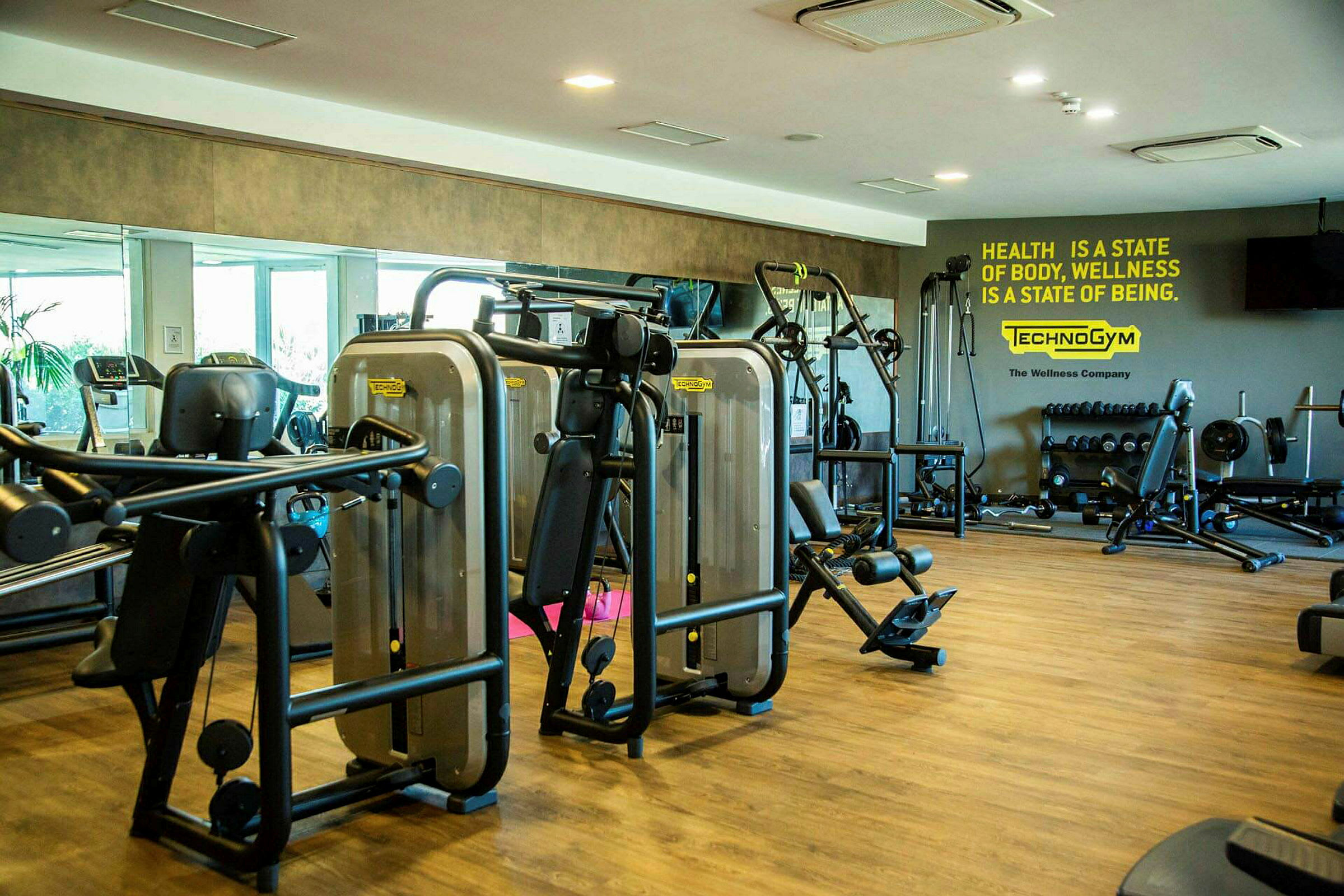 Ett gym med träningsmaskiner, vikter och spegelvägg. (AI-genererad text)