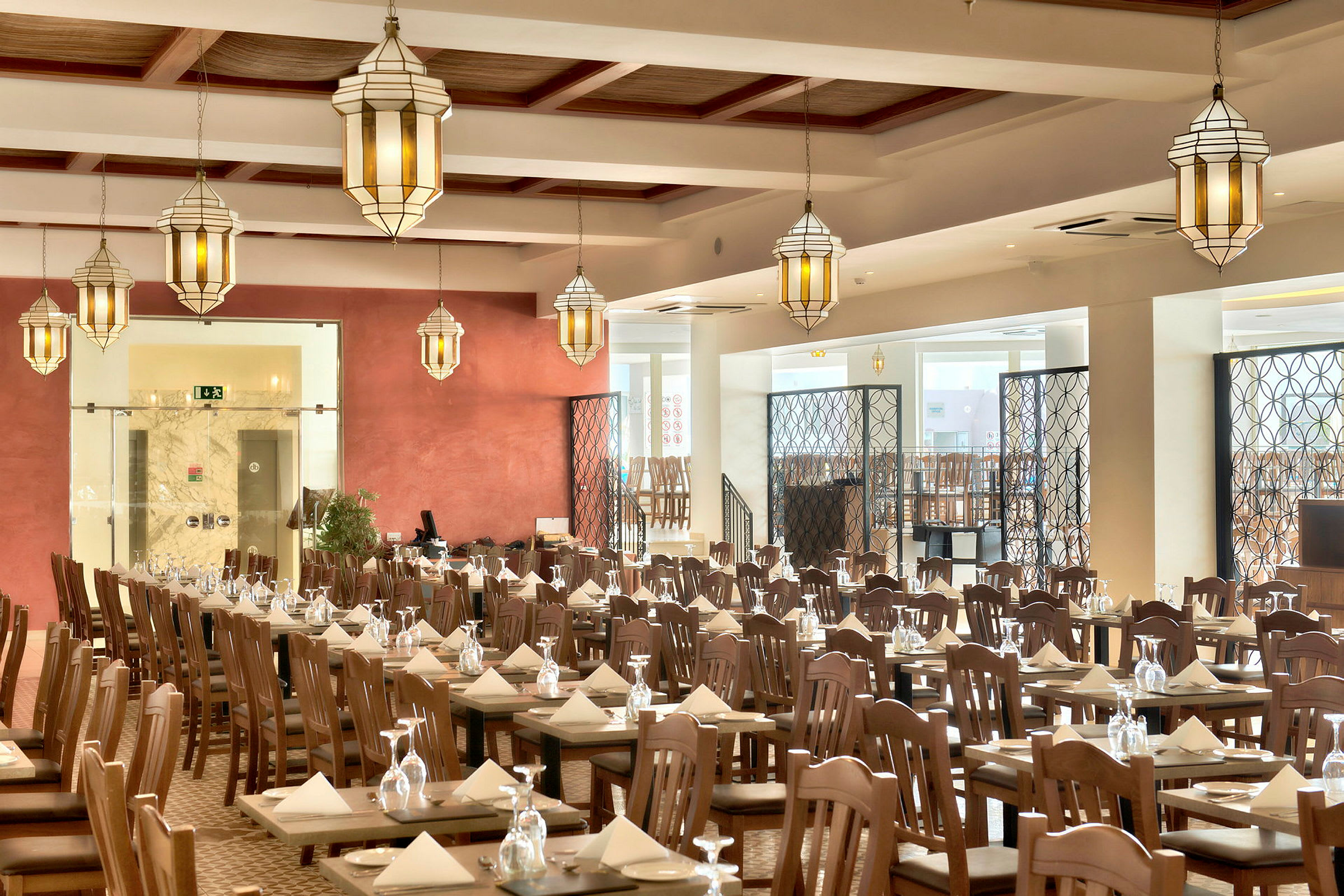 En restaurang med dukade bord, trästolar och hängande lyktor. (AI-genererad text)