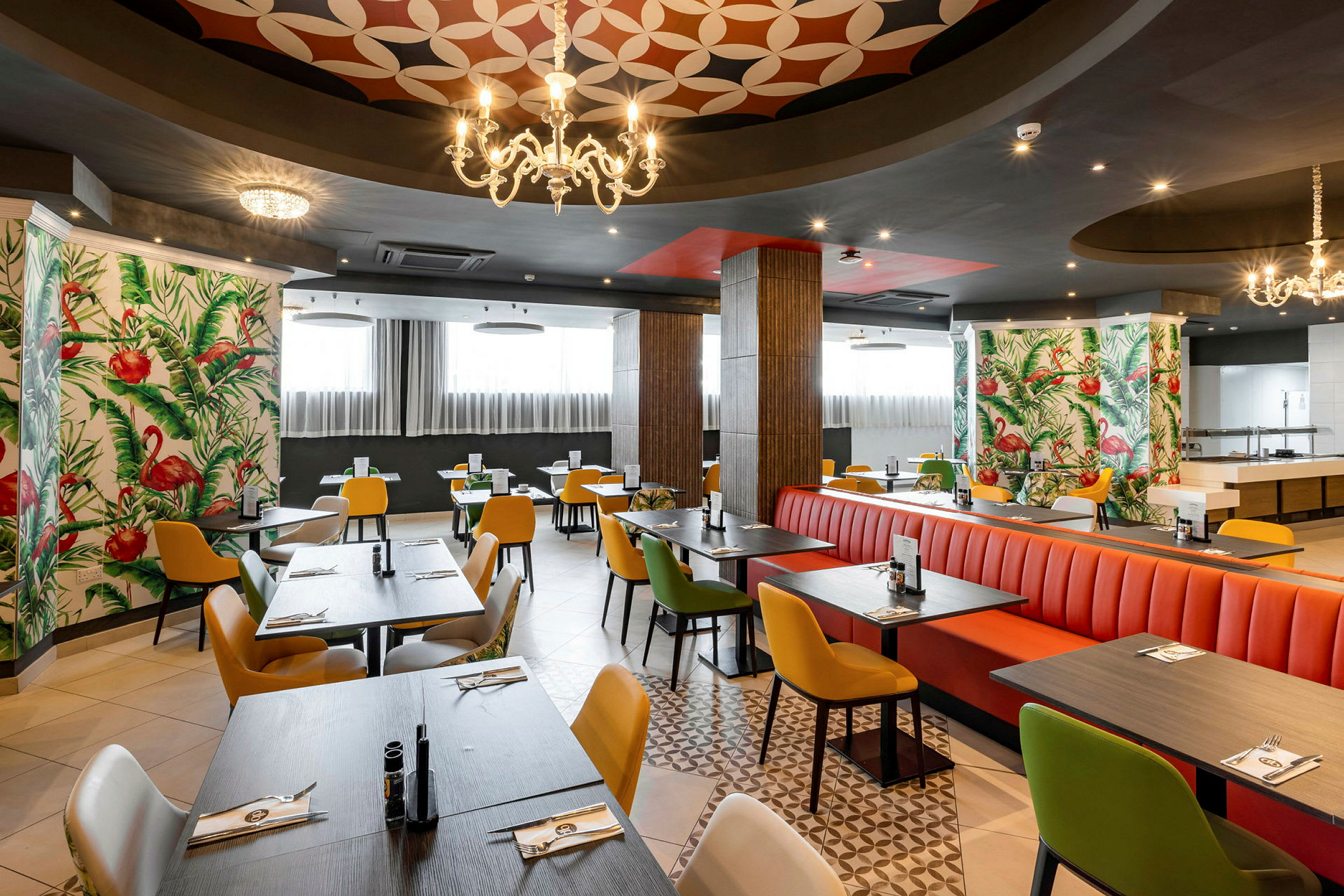 Restaurang med färgglada stolar och bord, dekorerad med flamingomönstrad tapet. (AI-genererad text)