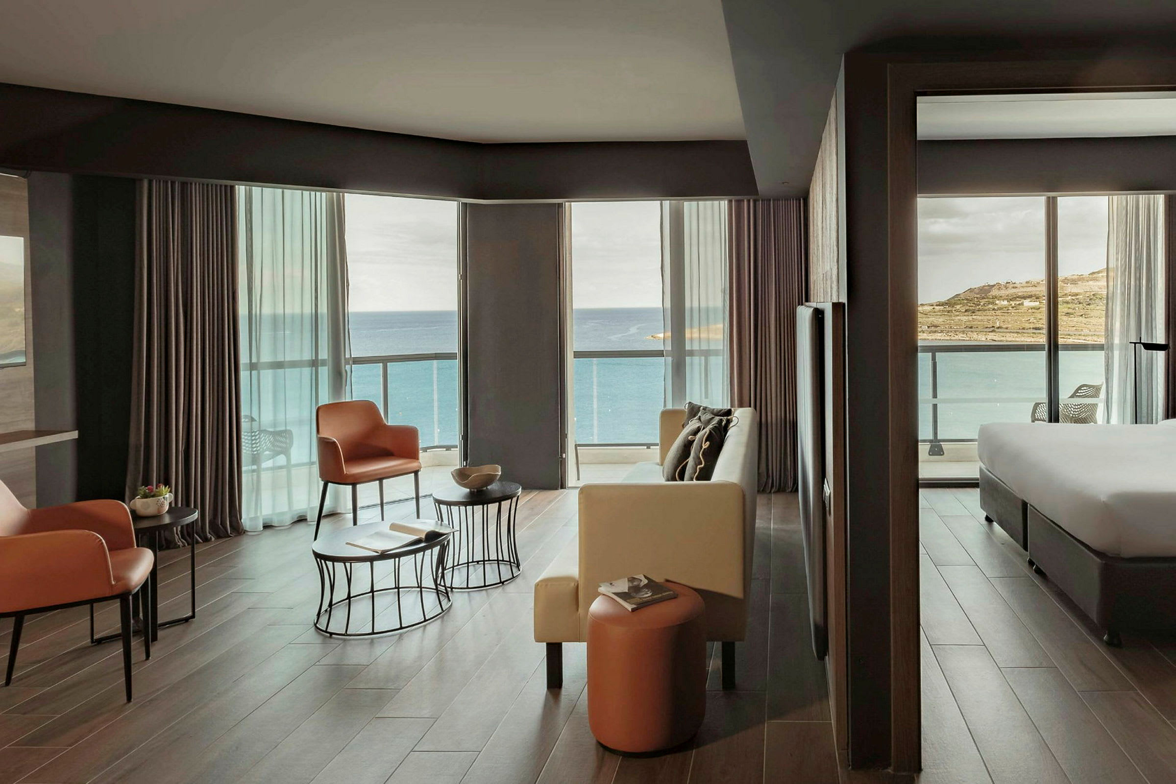 Ett hotellrum med modern inredning och stora fönster som vetter mot havet. (AI-genererad text)