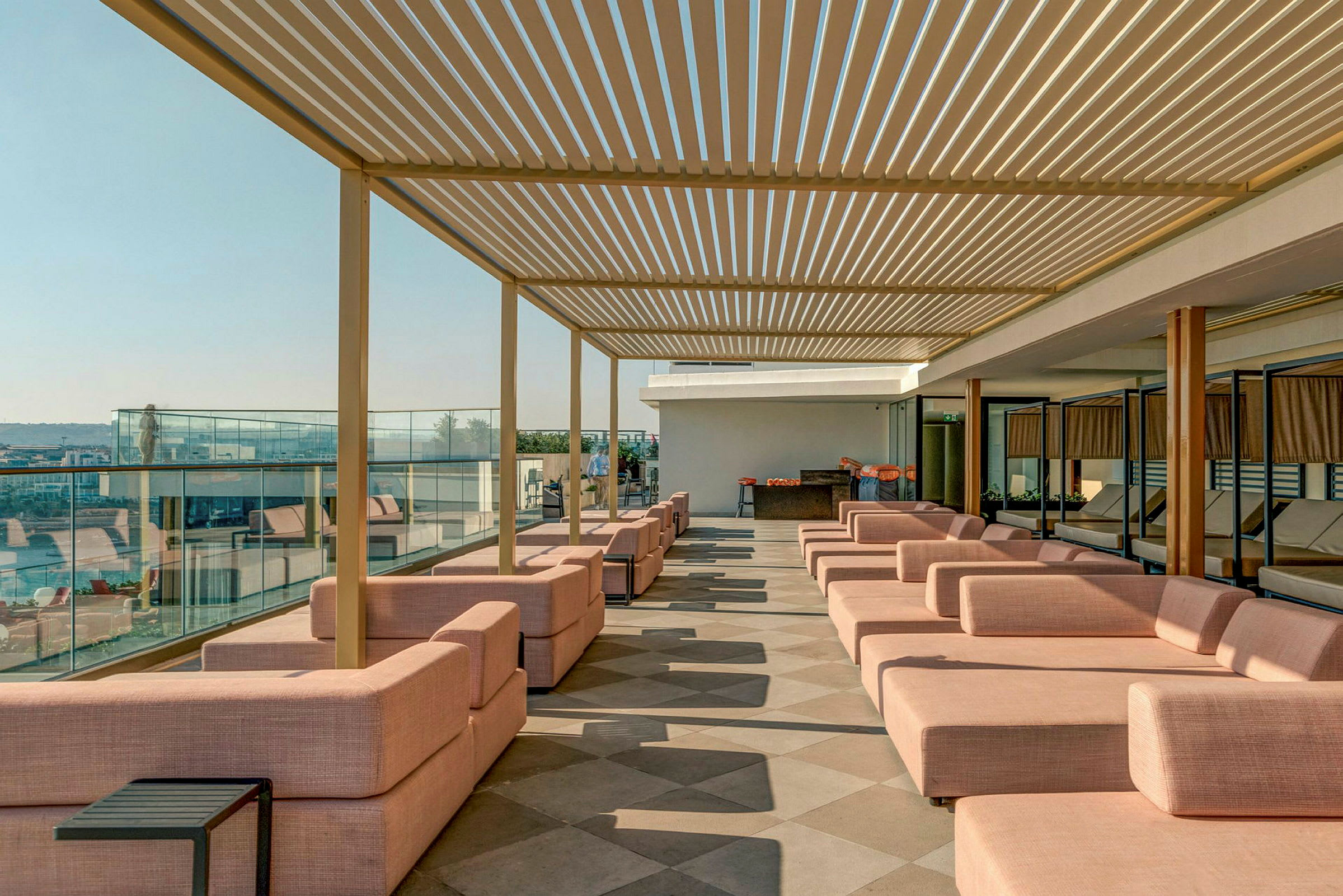 En terrass med rosa sittmöbler och en pergola i taket. (AI-genererad text)