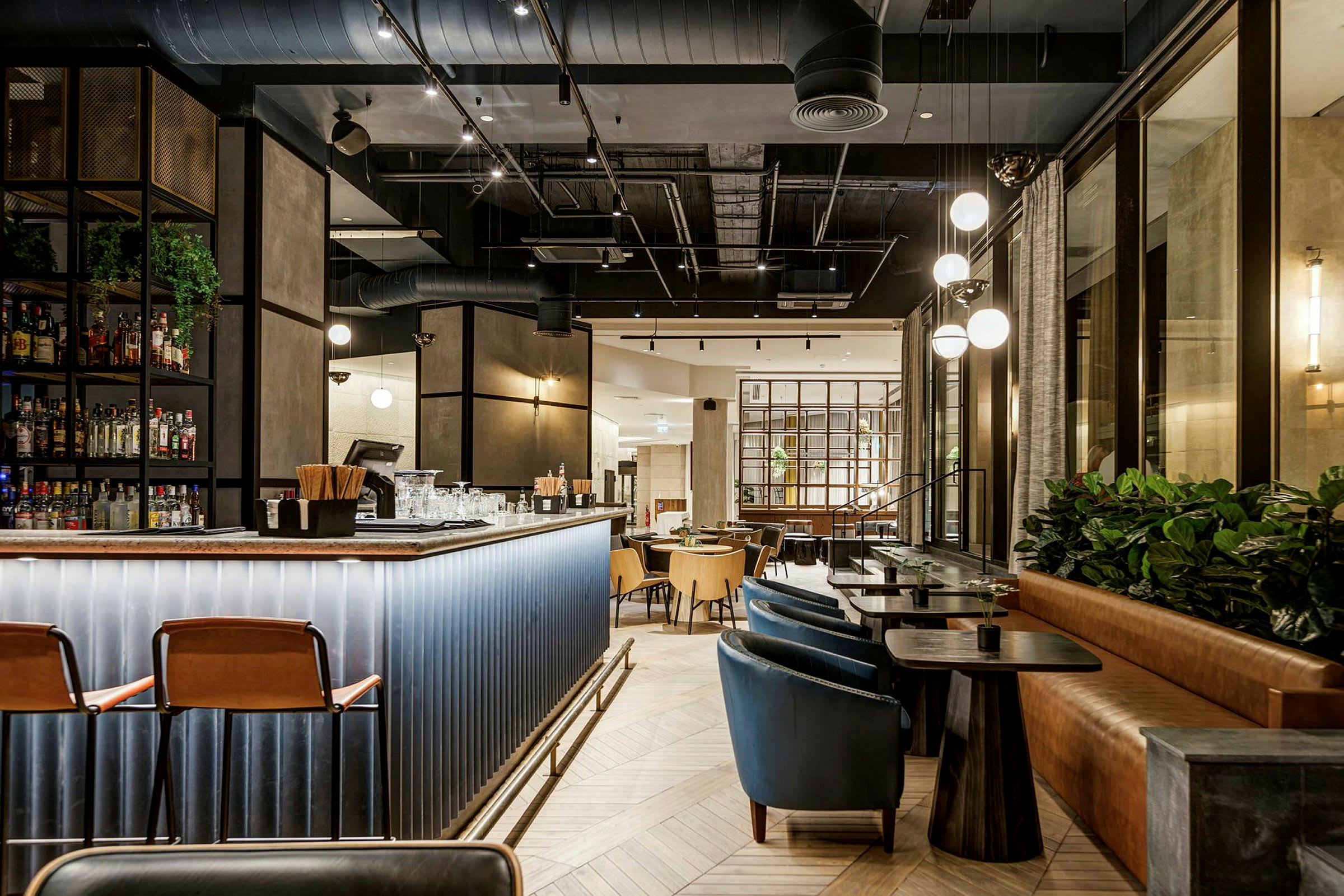 Modern interiör med bar och sittplatser samt dekorativa lampor. (AI-genererad text)