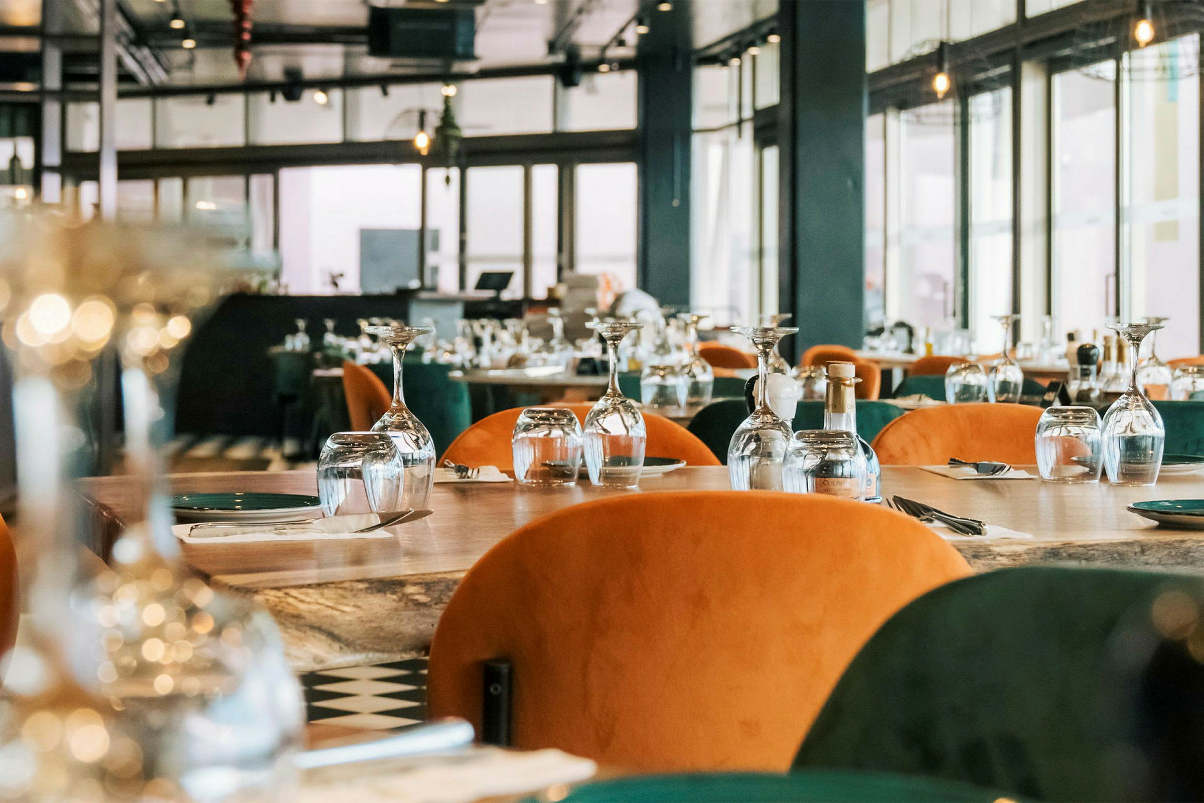 En restaurang med dukade bord, glas och bestick är uppställda för gäster. (AI-genererad text)