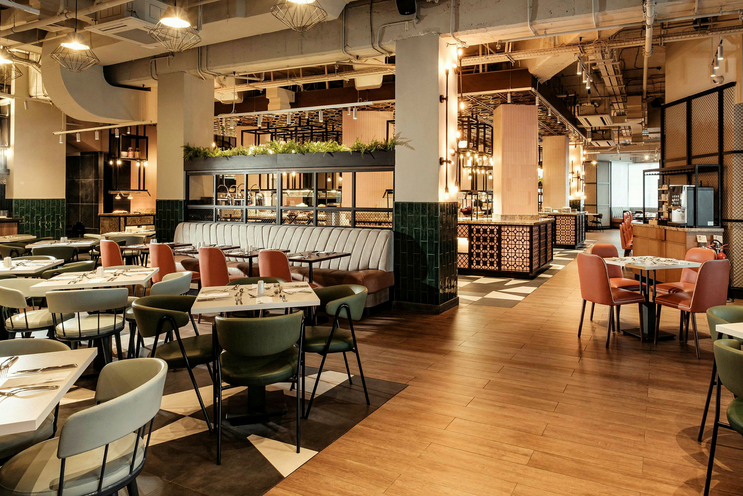 Bild av en modern restaurang med bord och stolar i olika färger, ljusa belysningar och en luftig design. (AI-genererad text)