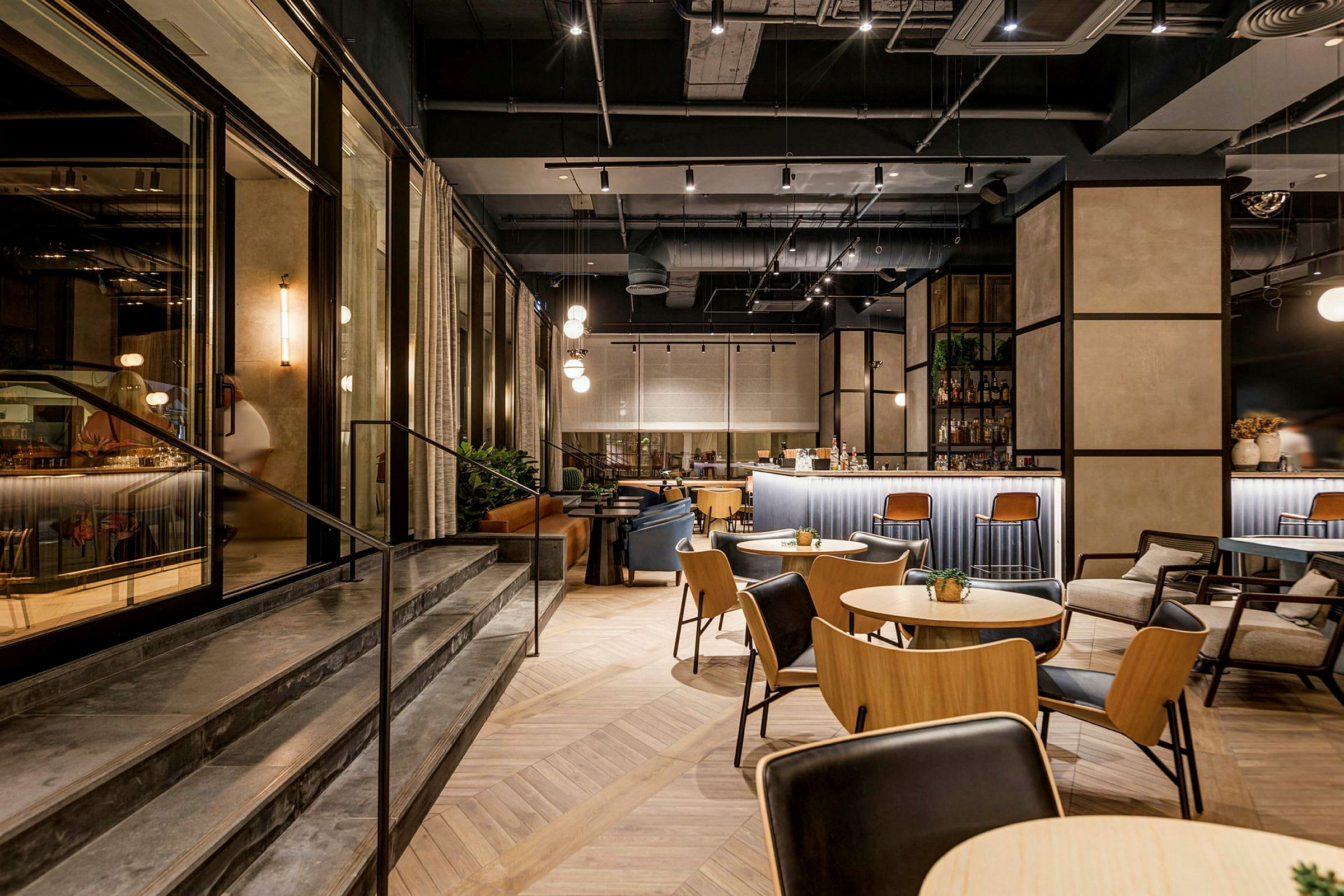 Interiör av en modern restaurang med bord, stolar och en bardisk. (AI-genererad text)