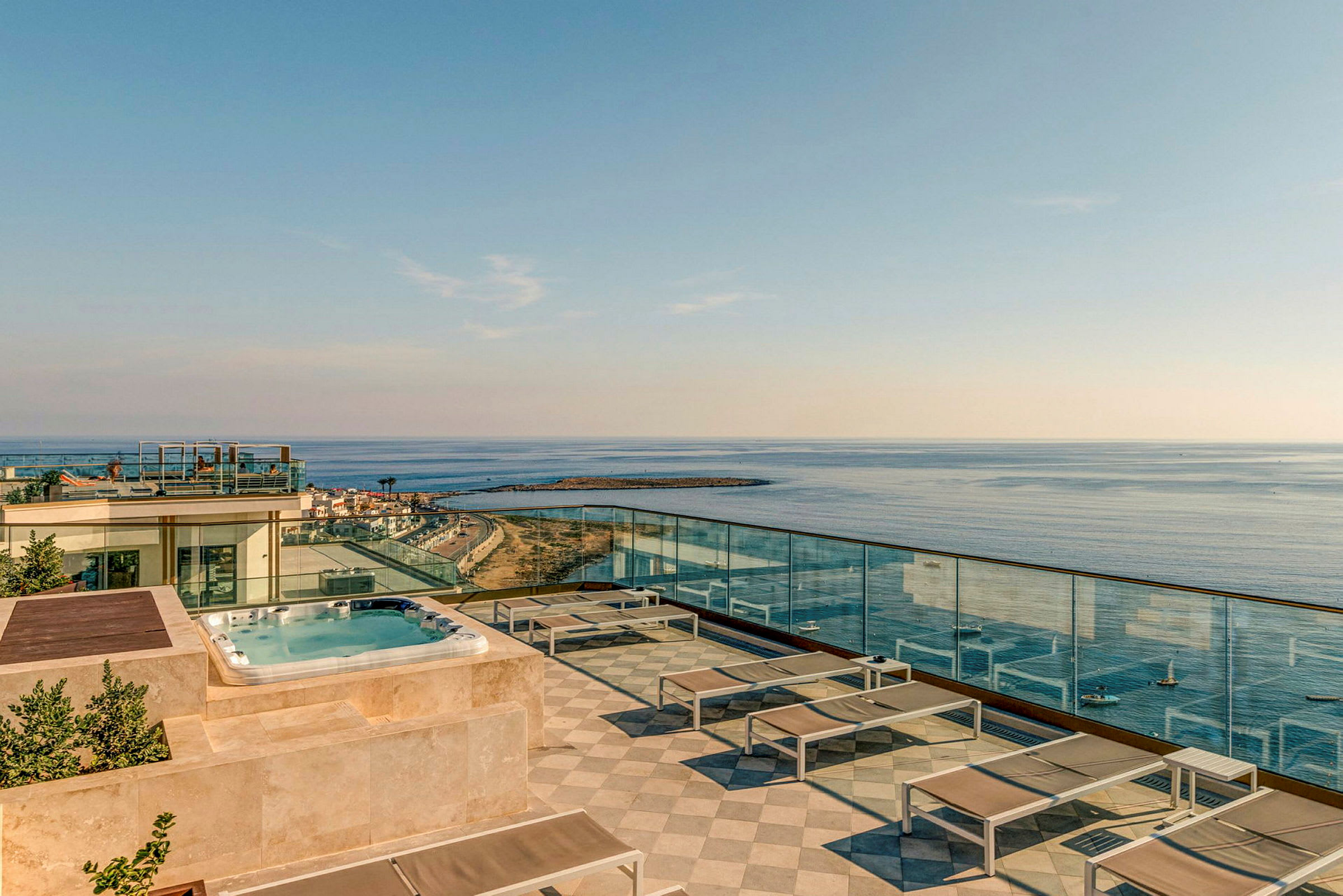 Takterrass med pool, solstolar och utsikt över havet. (AI-genererad text)