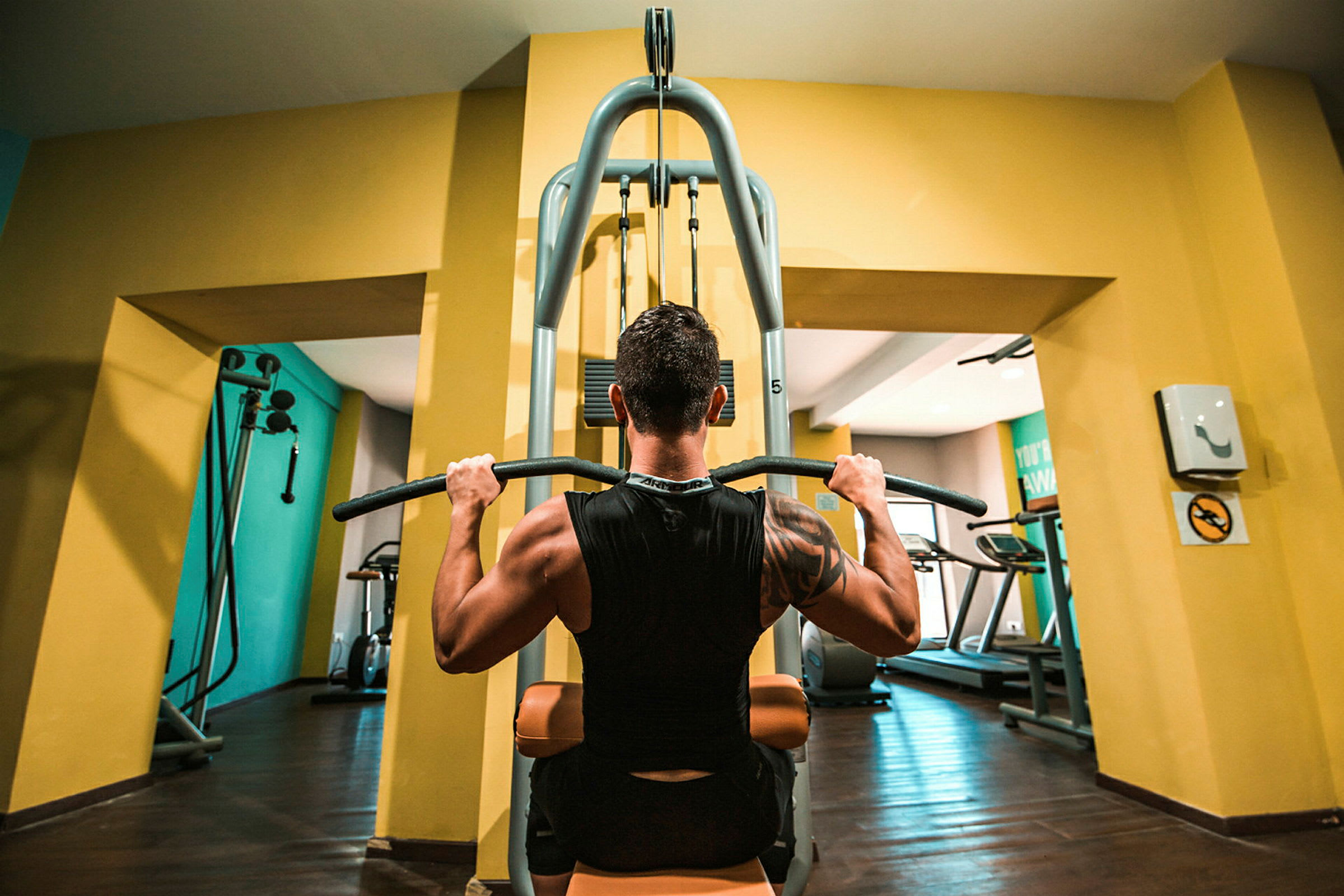En person använder en träningsmaskin i ett gym. (AI-genererad text)