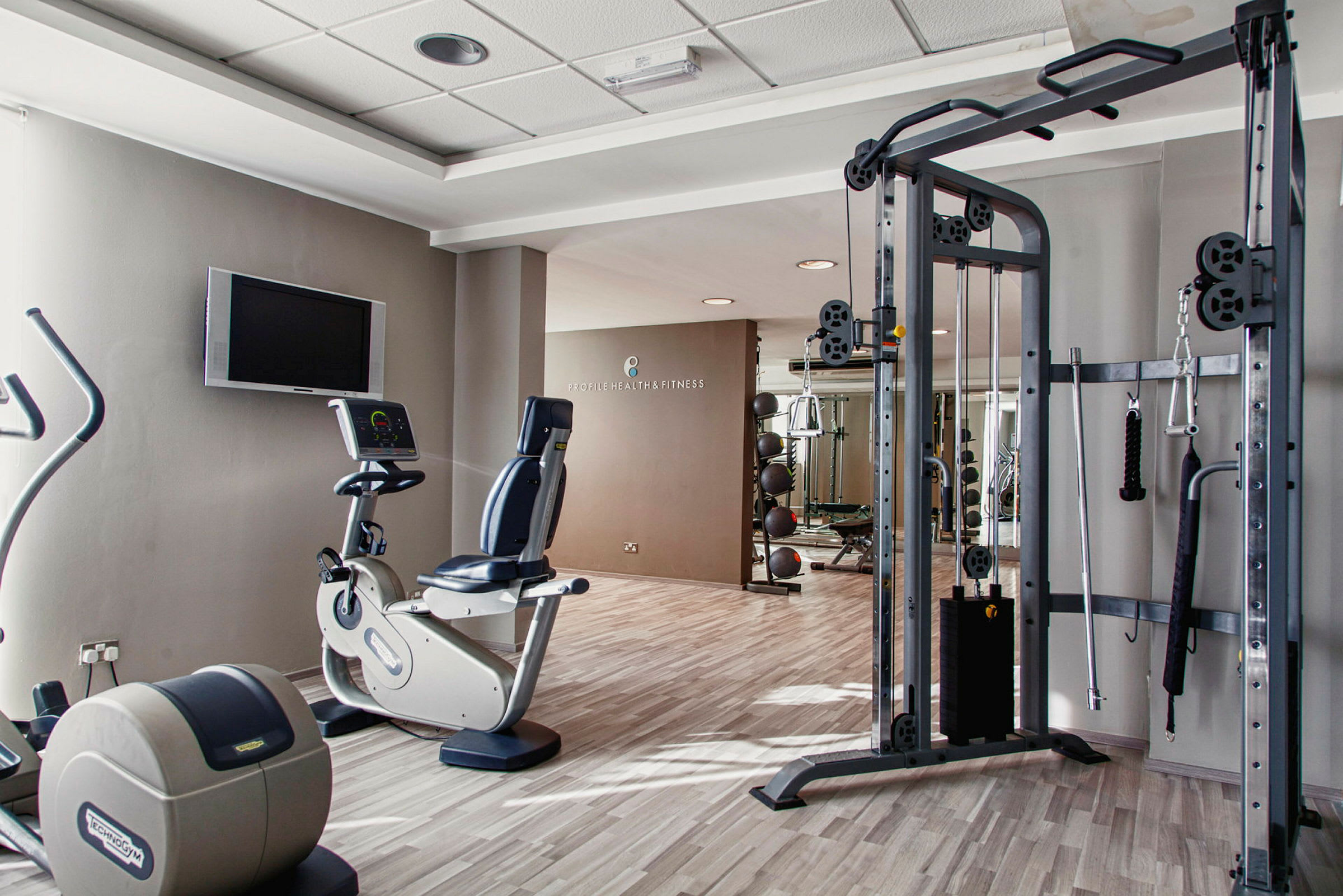 Ett gym med flera träningsmaskiner och utrustning. (AI-genererad text)
