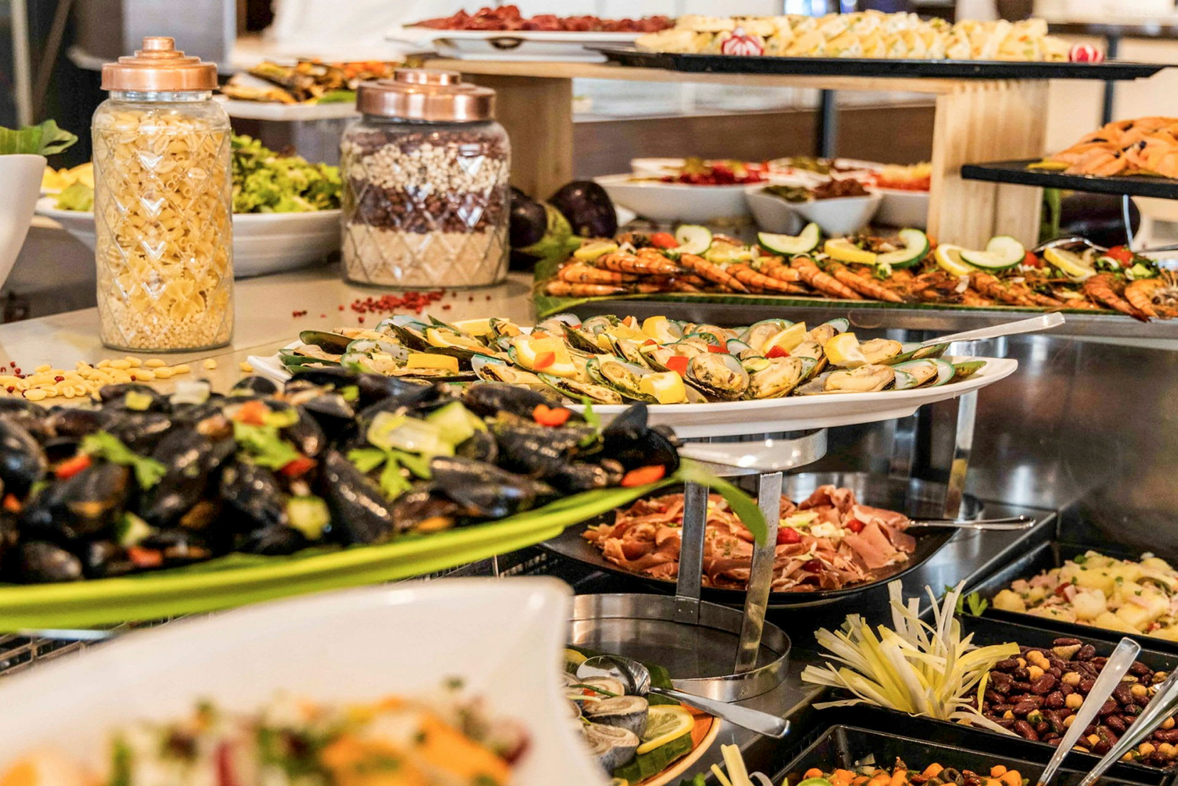 En buffé med olika maträtter såsom musslor, räkor, och pastasallad. (AI-genererad text)
