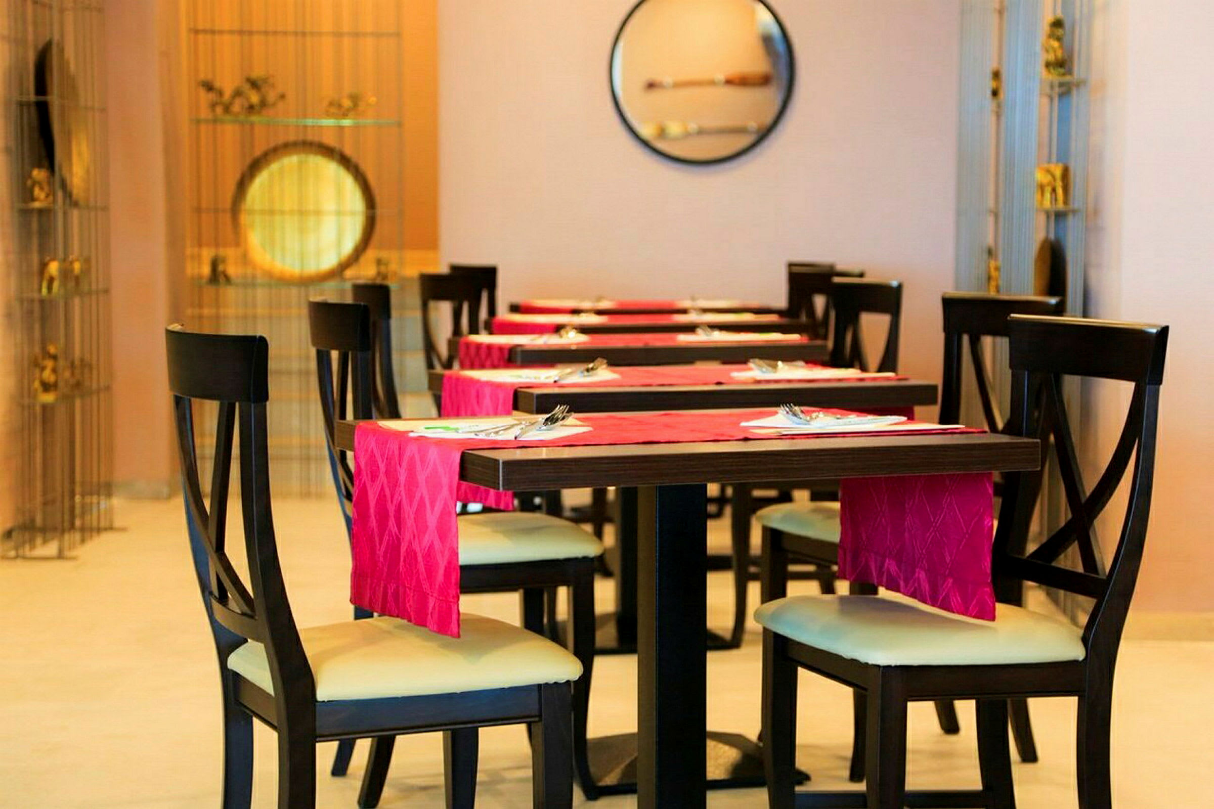 Restaurangbord och stolar med röd servett. (AI-genererad text)