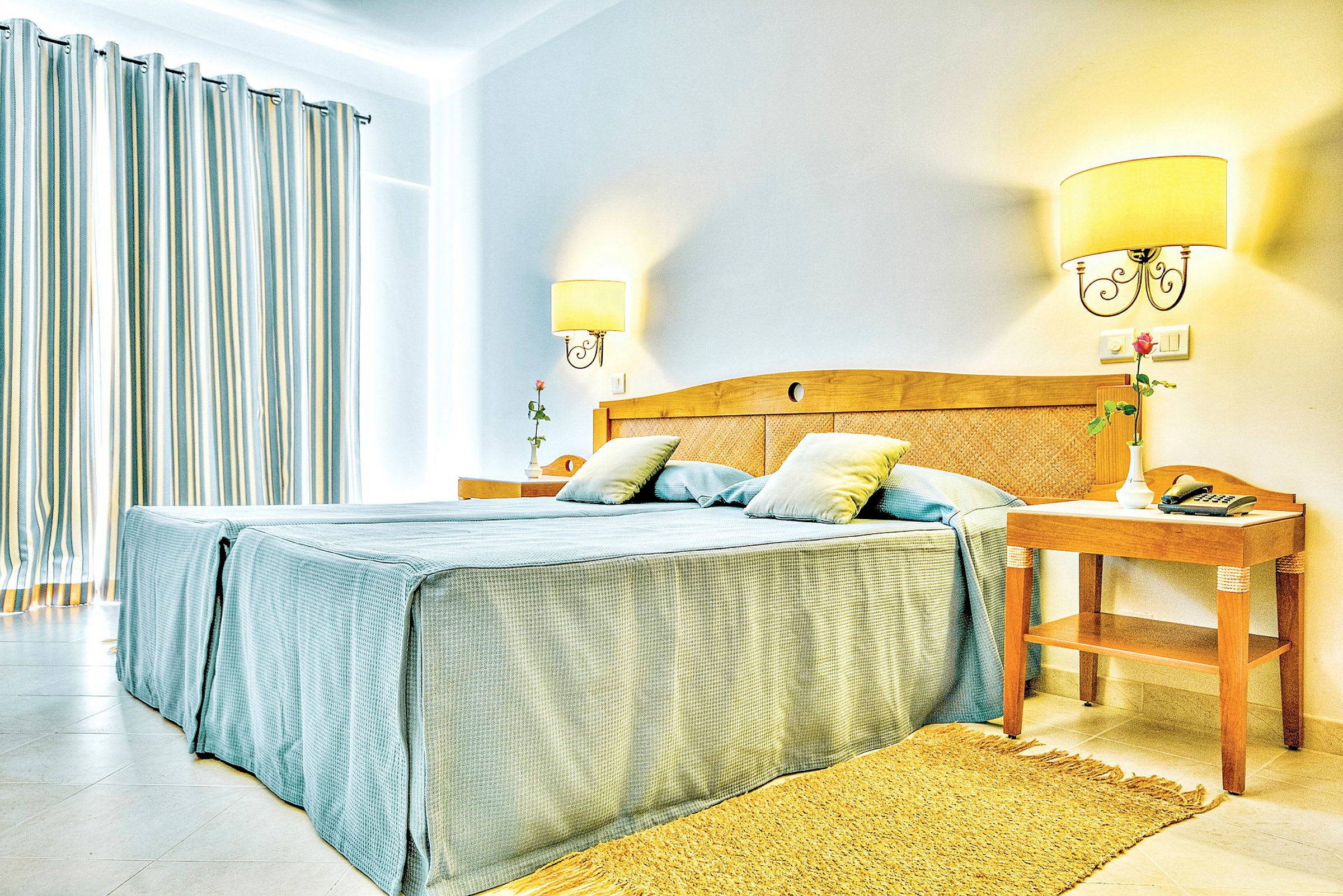 Bild av ett ljust hotellrum med en dubbelsäng och nattygsbord. (AI-genererad text)