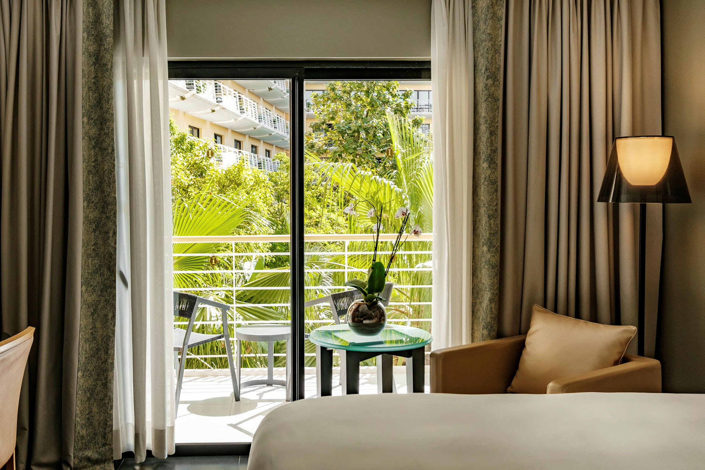 Hotellrum med utsikt mot en grönskande balkong. (AI-genererad text)