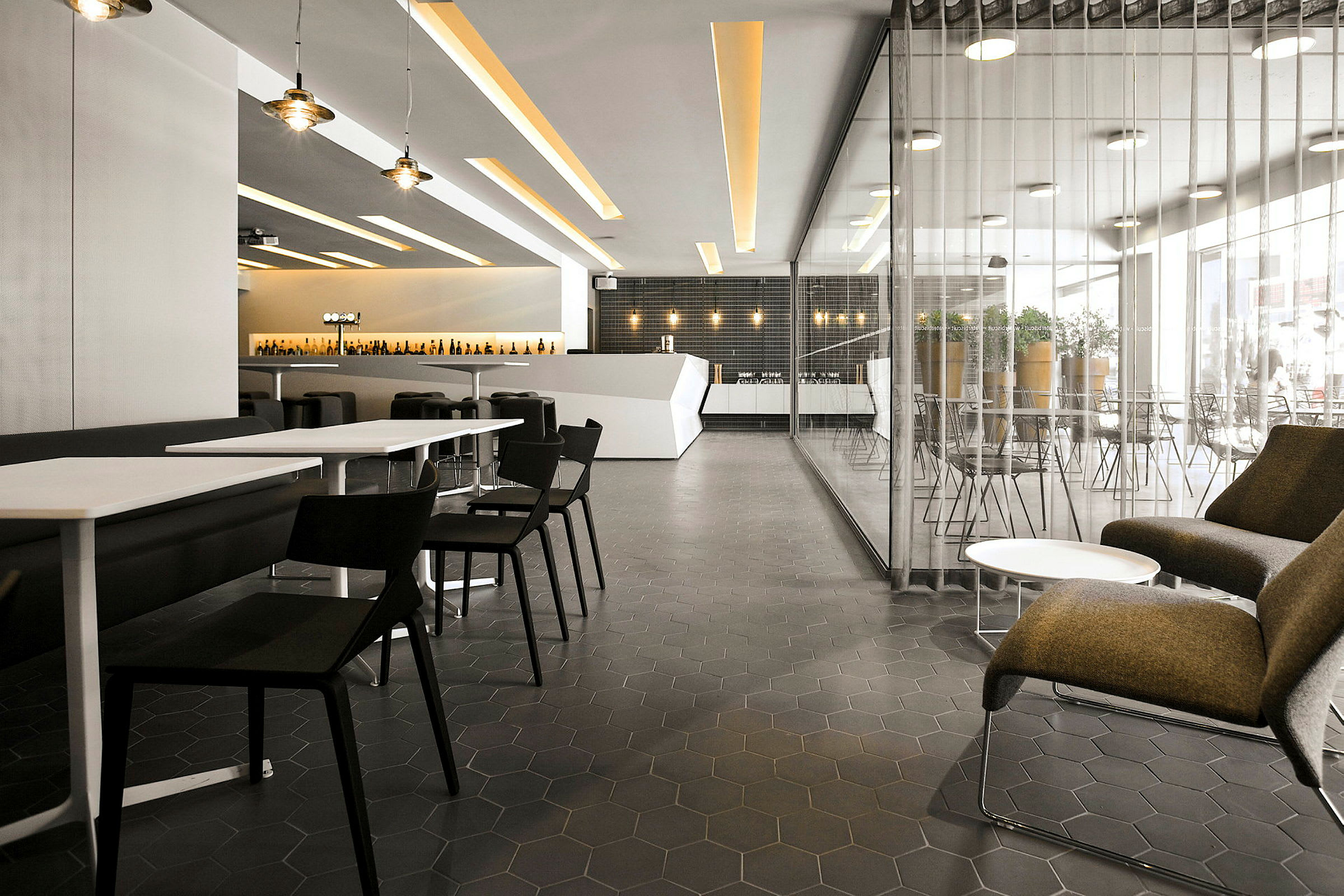 Interiör av en modern restaurang med bord, stolar och loungeområde. (AI-genererad text)