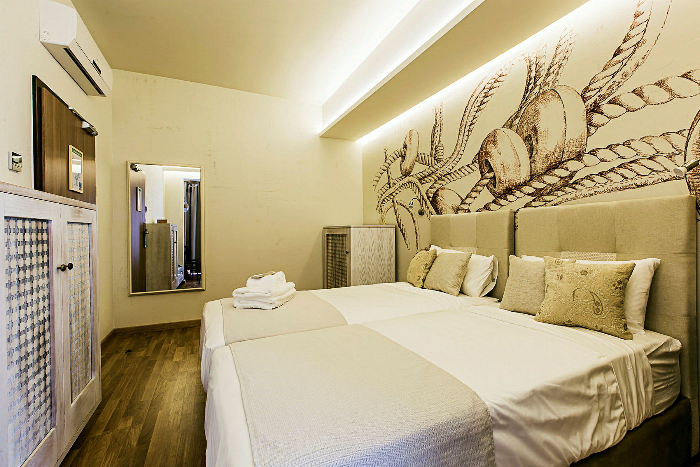 Ett hotellrum med två sängar, prydliga sängkläder och dekorativ väggtapet. (AI-genererad text)