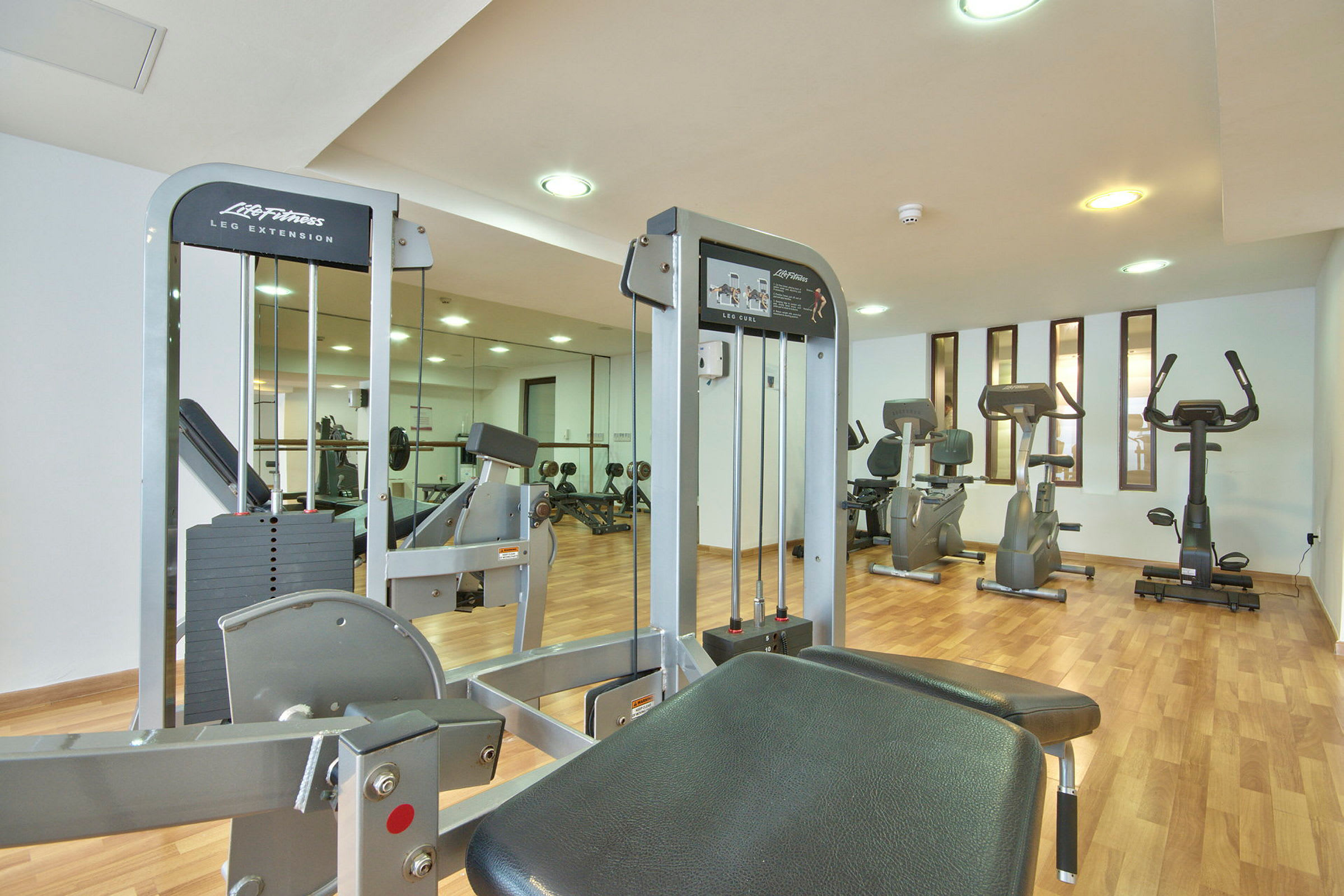 Ett gym med flera träningsmaskiner och spegelvägg. (AI-genererad text)
