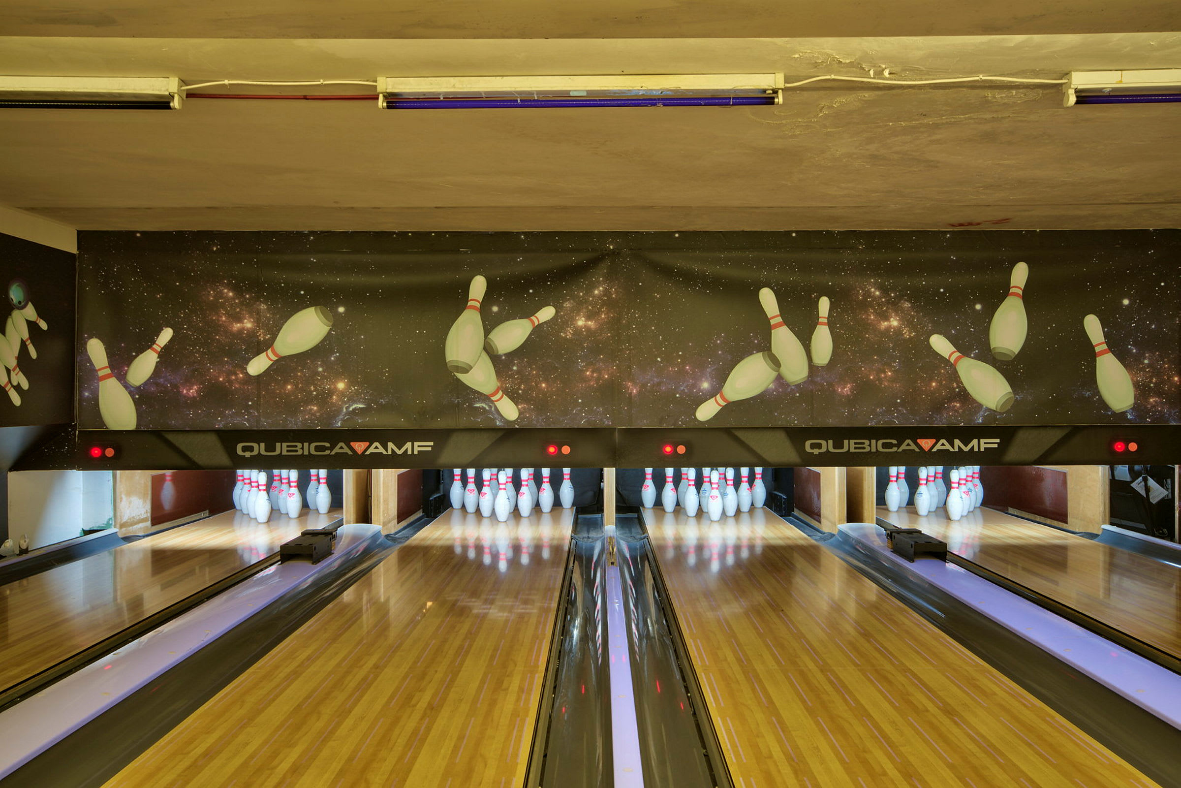 Ett bowlinghall med träbanor och käglor i slutet av banorna. (AI-genererad text)
