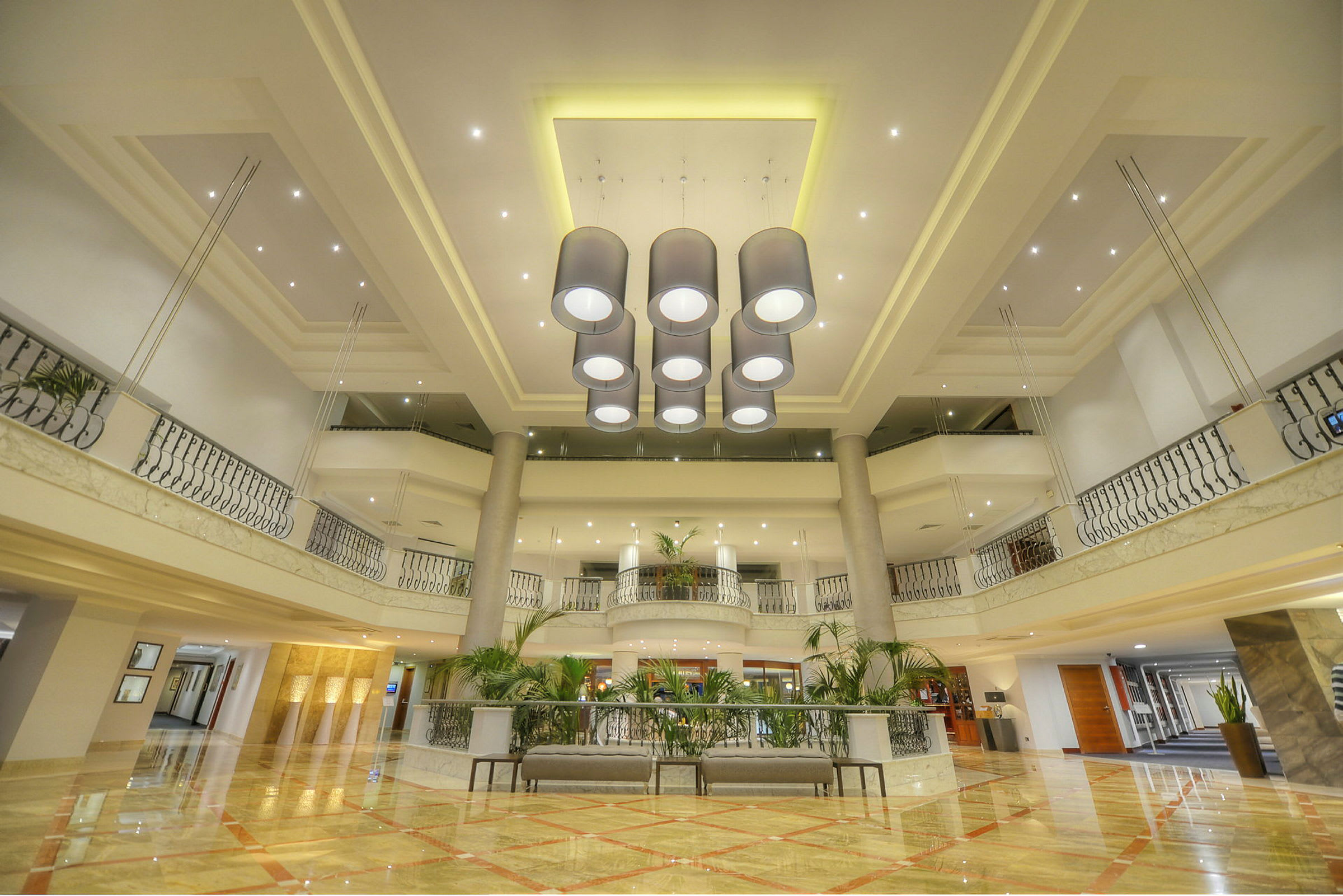 Bild på elegant hotellobby med en ljuskrona i centrum och modern inredning. (AI-genererad text)