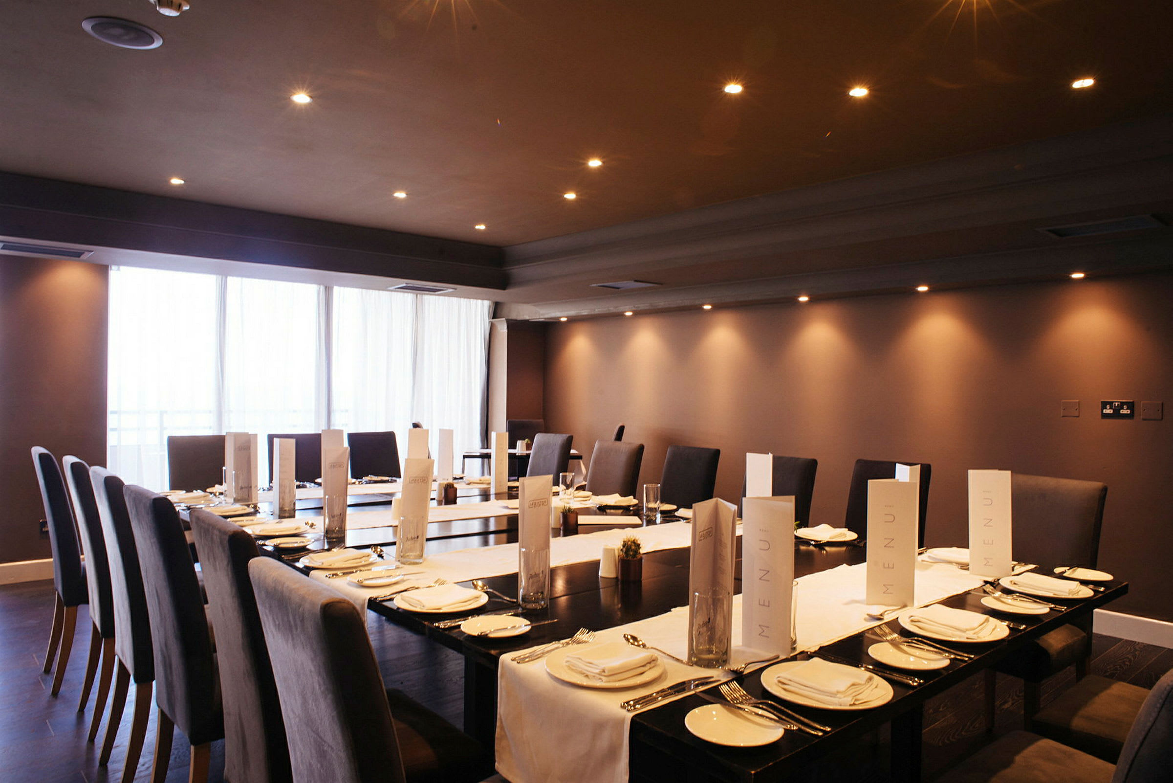 Ett dukat bord i en elegant restaurangmiljö med menyer och lämplig belysning. (AI-genererad text)