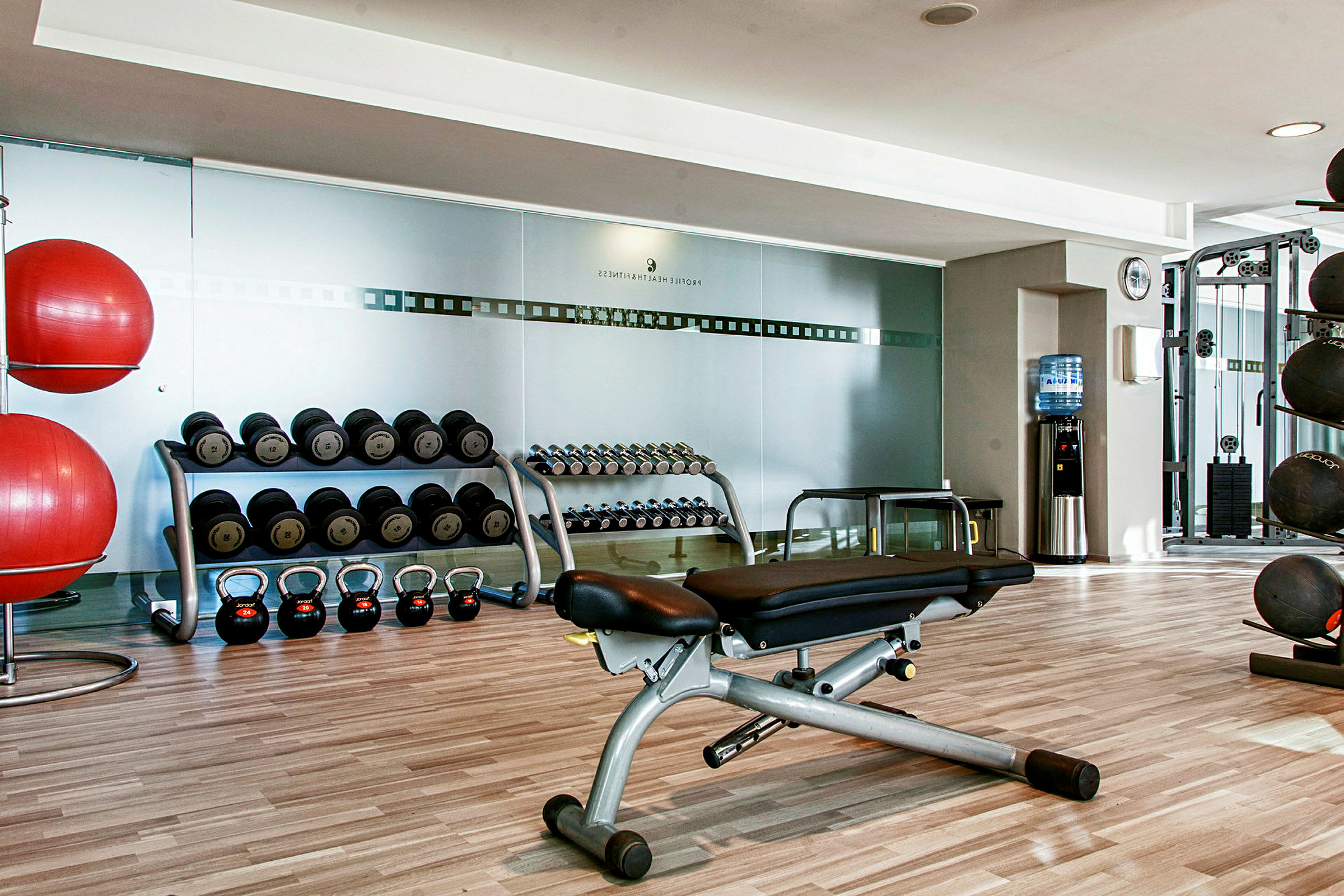 Ett gym med vikter, träningsbänkar, kettlebells och träningsbollar. (AI-genererad text)