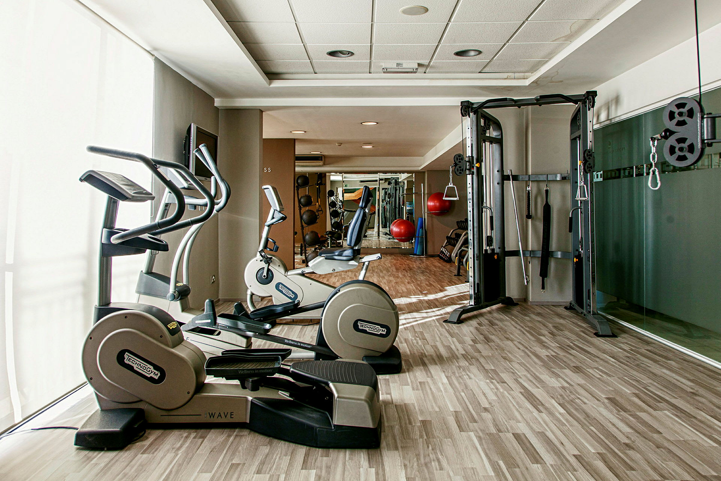 Ett gym med träningsmaskiner och utrustning, inklusive motionscyklar och kabelmaskiner. (AI-genererad text)