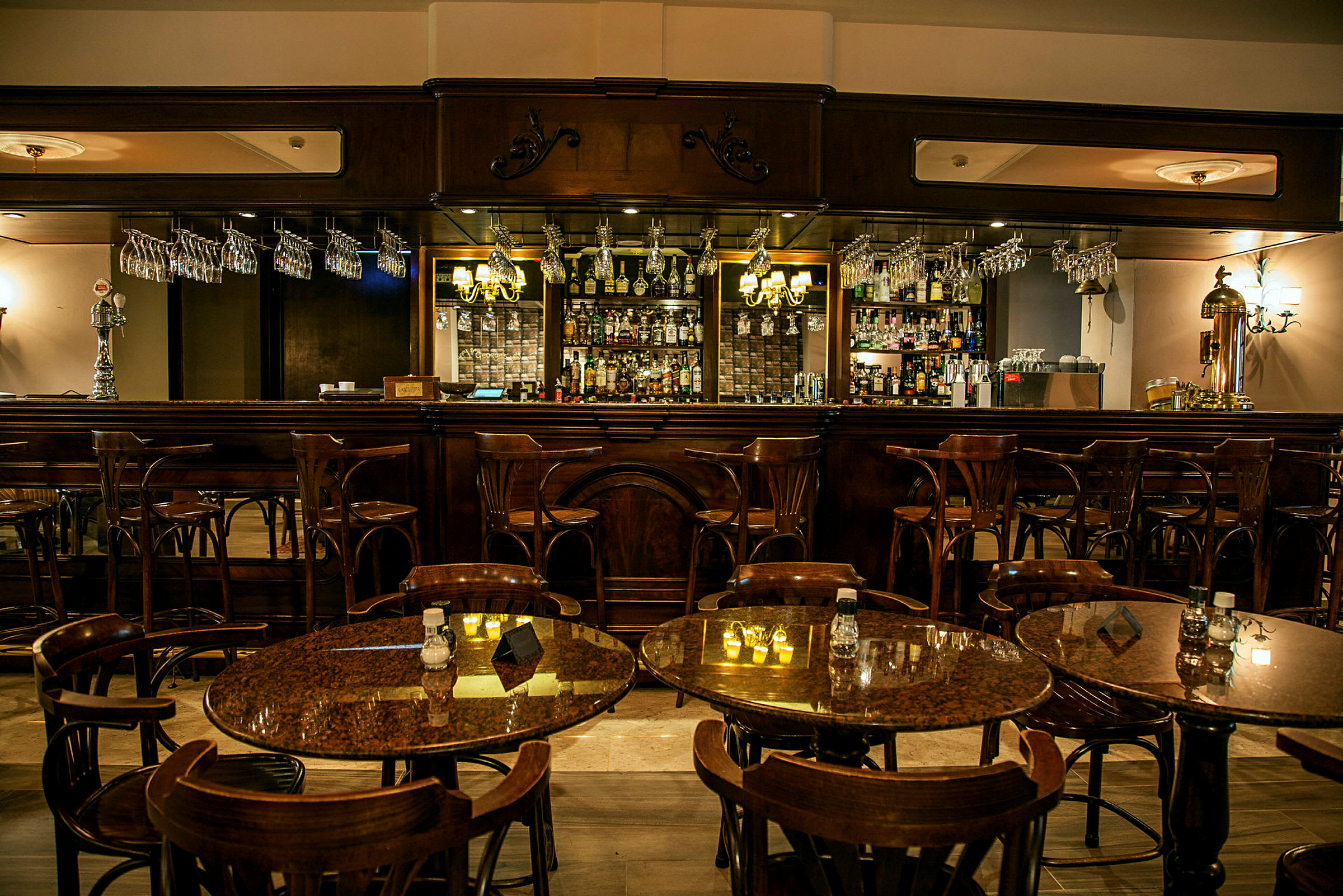 En elegant bar med träinredning och bordsgrupper med stolar i förgrunden. (AI-genererad text)