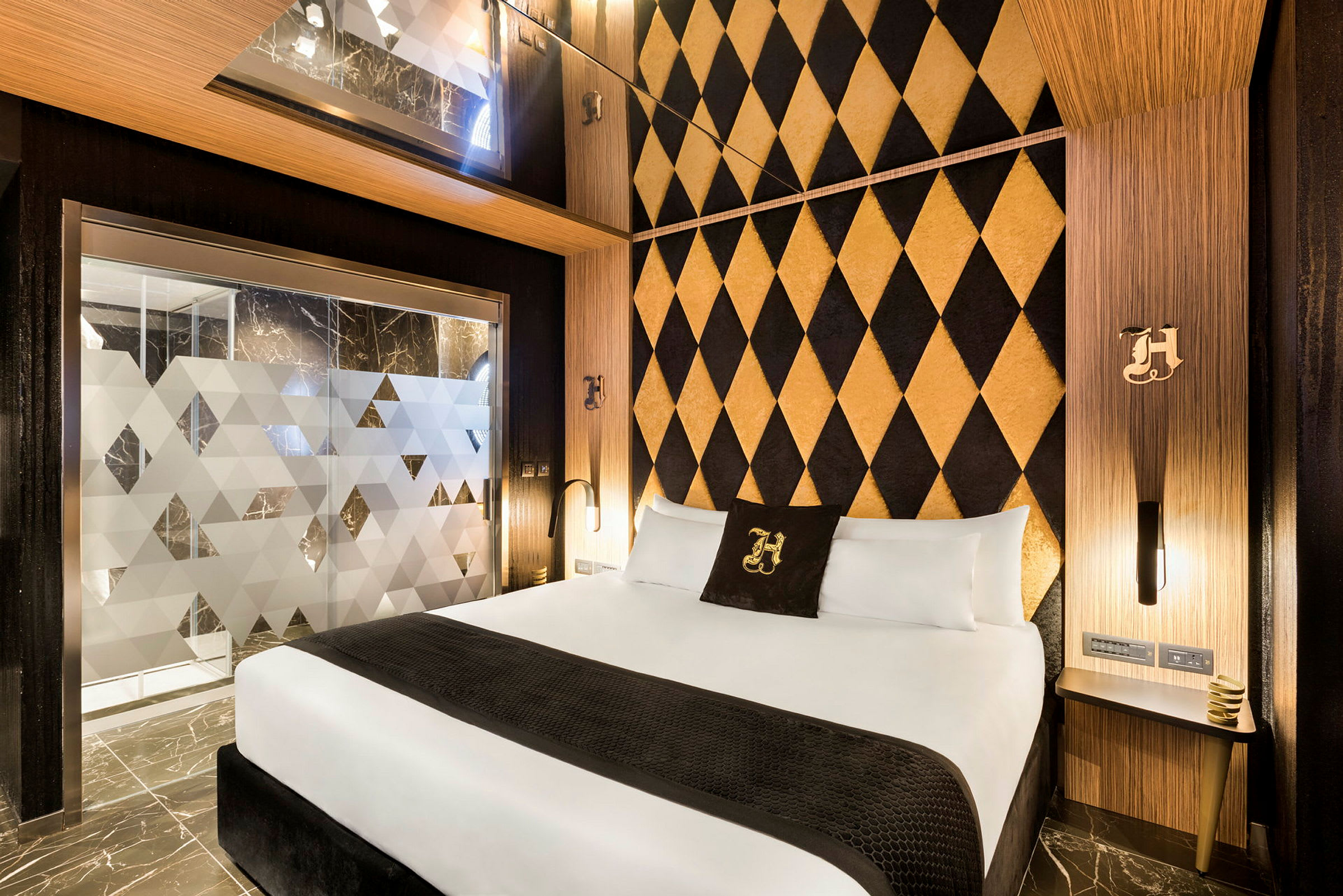 Hotellrum med modern inredning, dubbelrumssäng och dekorativt mönstrad vägg. (AI-genererad text)