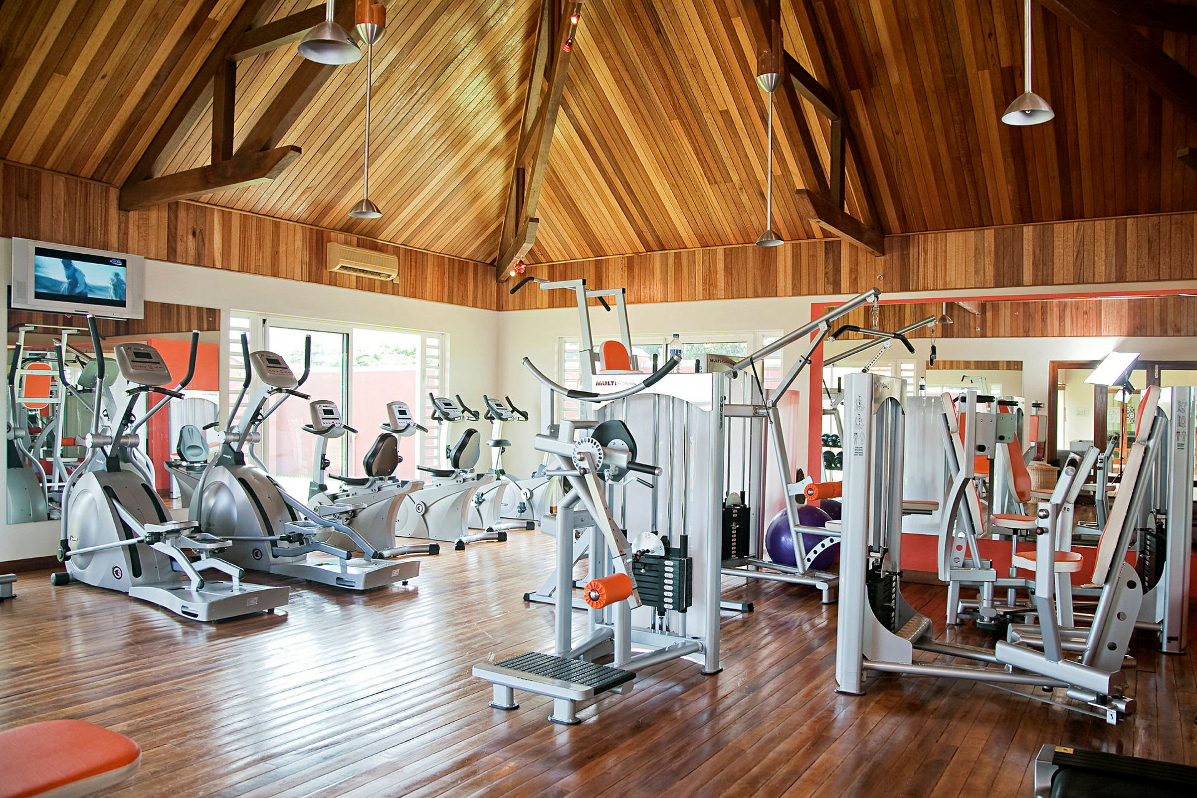 Ett gym med träningsmaskiner och träväggar. (AI-genererad text)