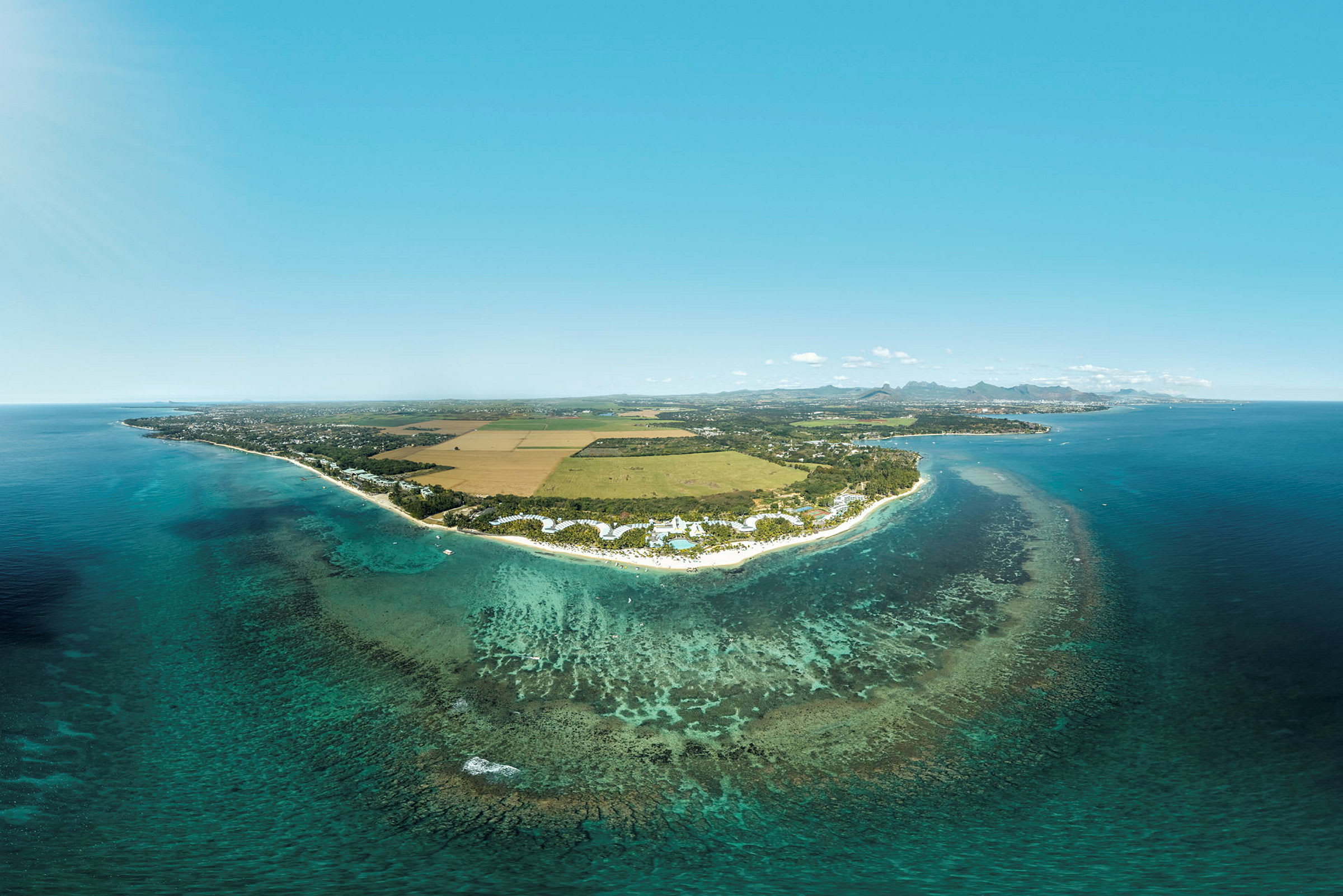 Flygfoto av en kust med turkost vatten, sandstränder och omgivande landskap. (AI-genererad text)