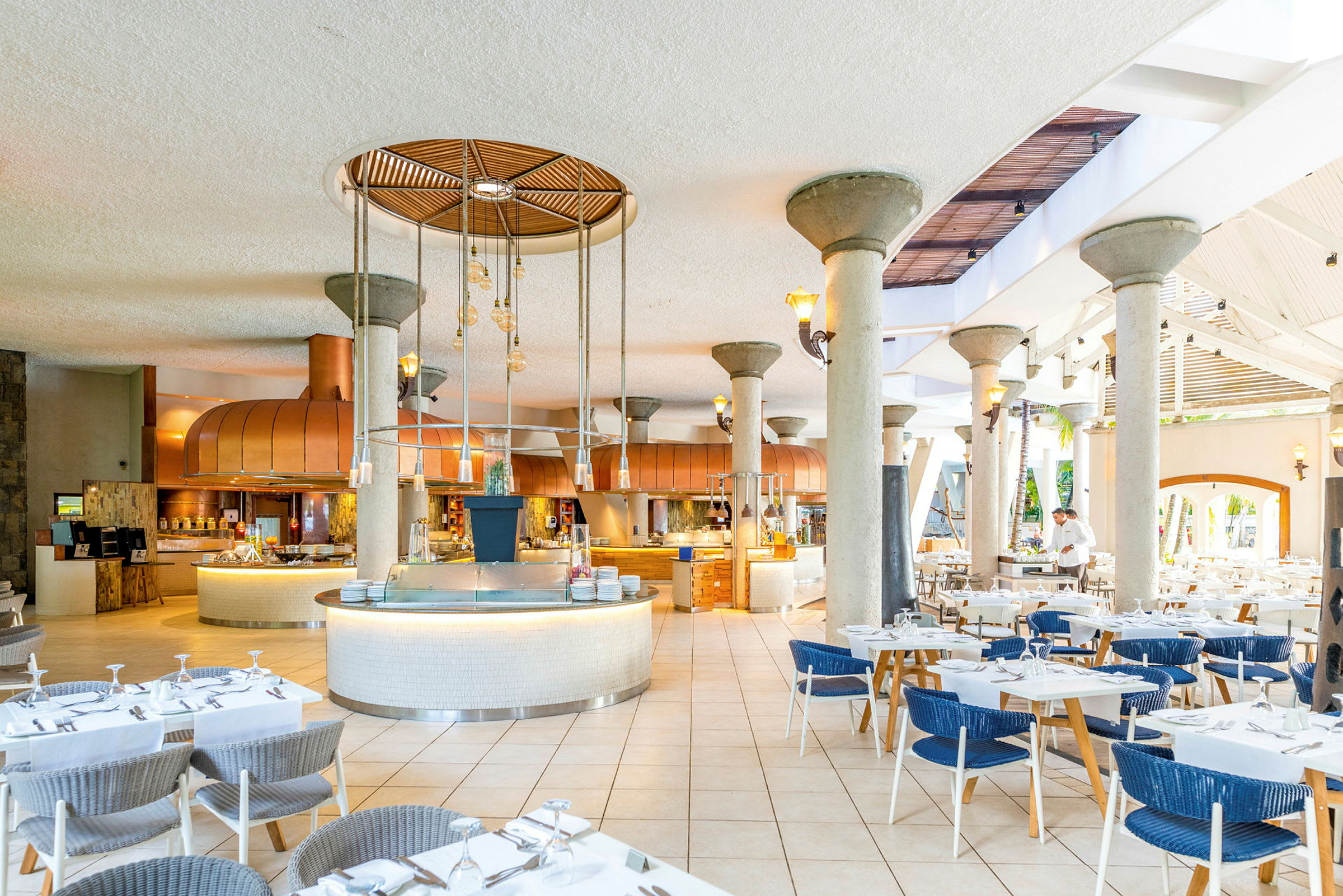 Bild av en restaurang med dukade bord och ett öppet köksområde. (AI-genererad text)