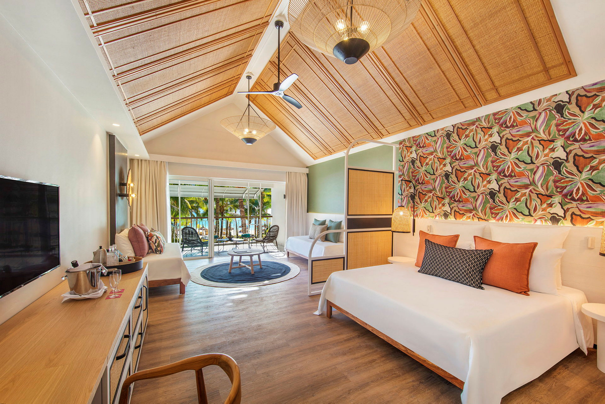 Ett elegant hotellrum med säng, sittgrupp och utsikt över trädgård genom skjutdörrar. (AI-genererad text)