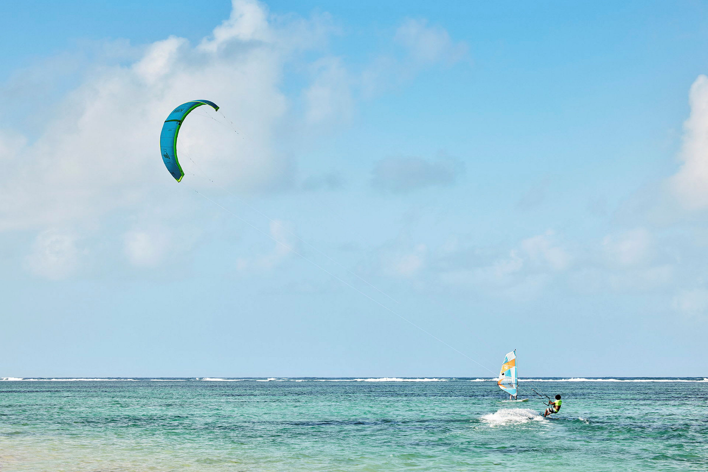 Person som kitesurfar på havet under en blå himmel. (AI-genererad text)