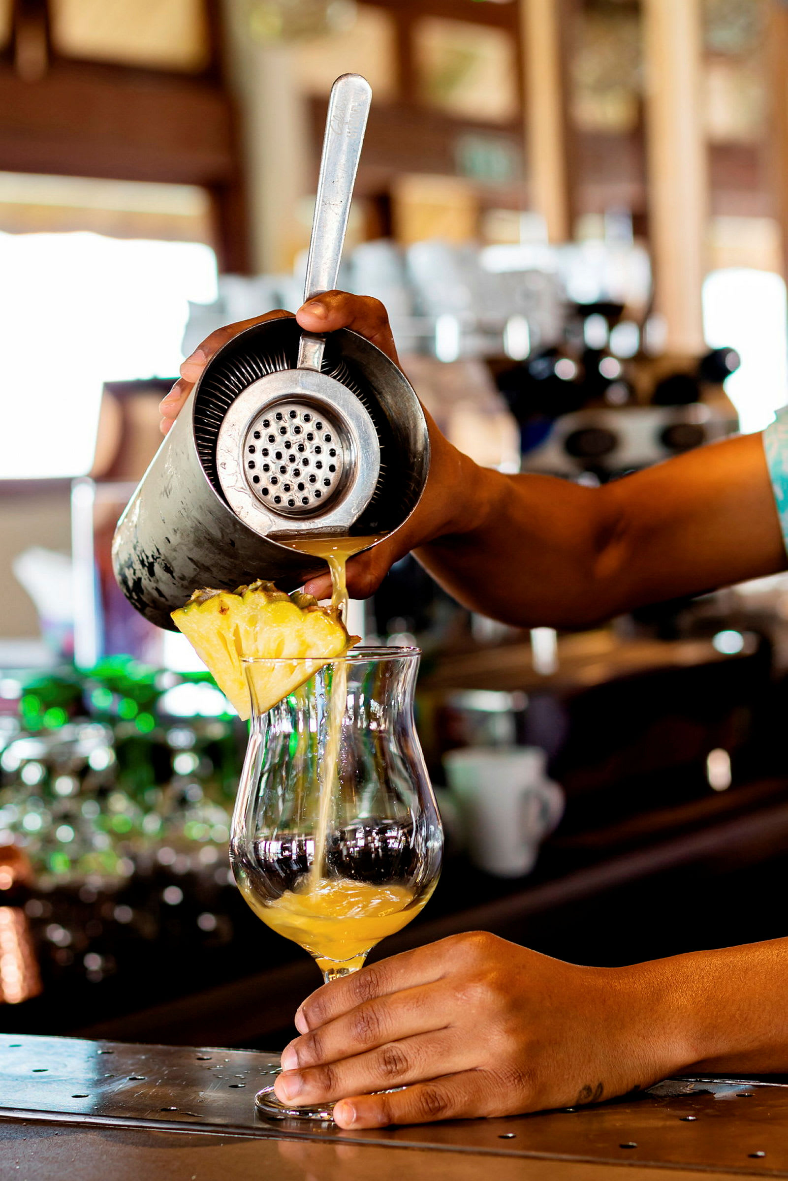 En drink hälls upp i ett glas på en bardisk. (AI-genererad text)