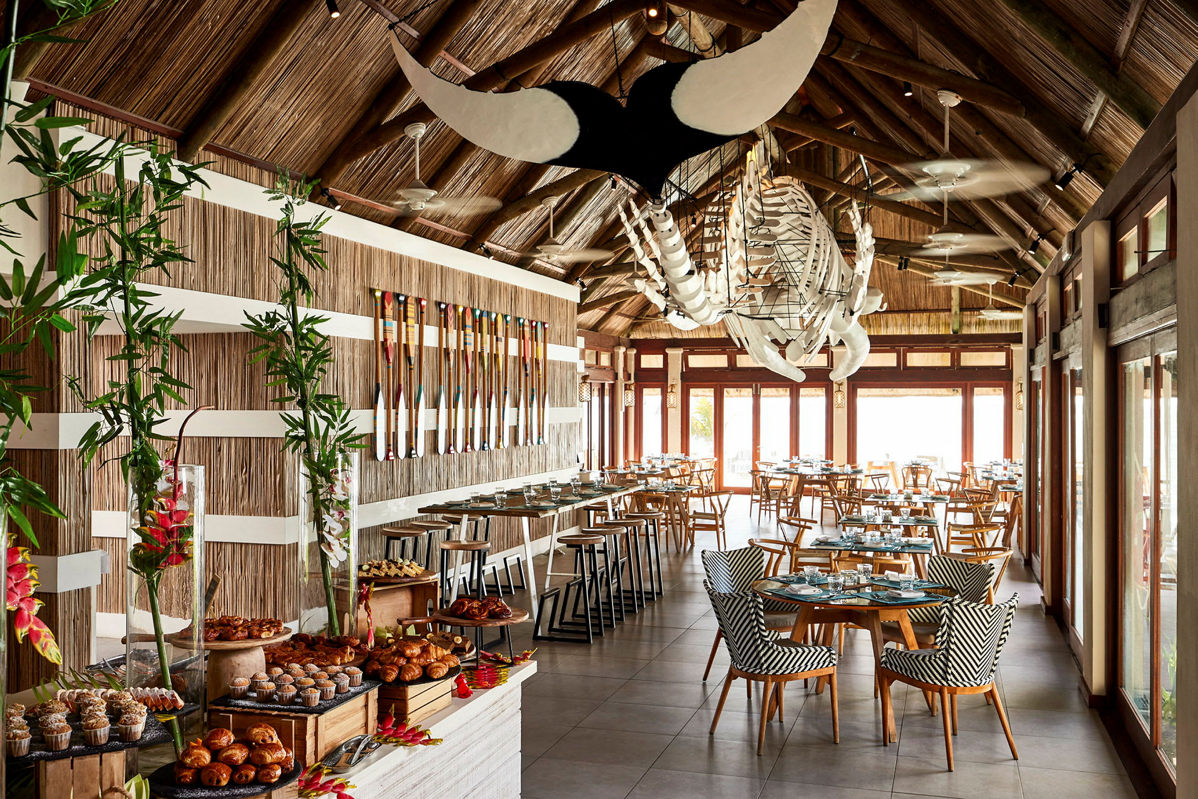 En restaurang med dukade bord, trädetaljer och dekorativ belysning. (AI-genererad text)