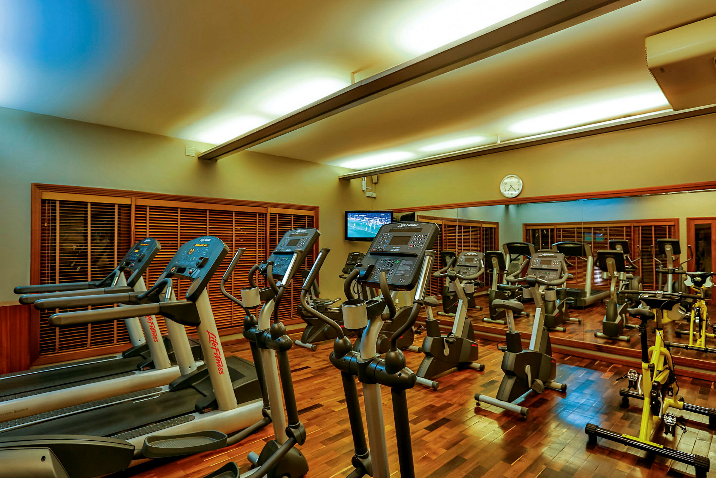 Ett gym med träningsmaskiner inklusive löpband, träningscyklar och träningsutrustning. (AI-genererad text)