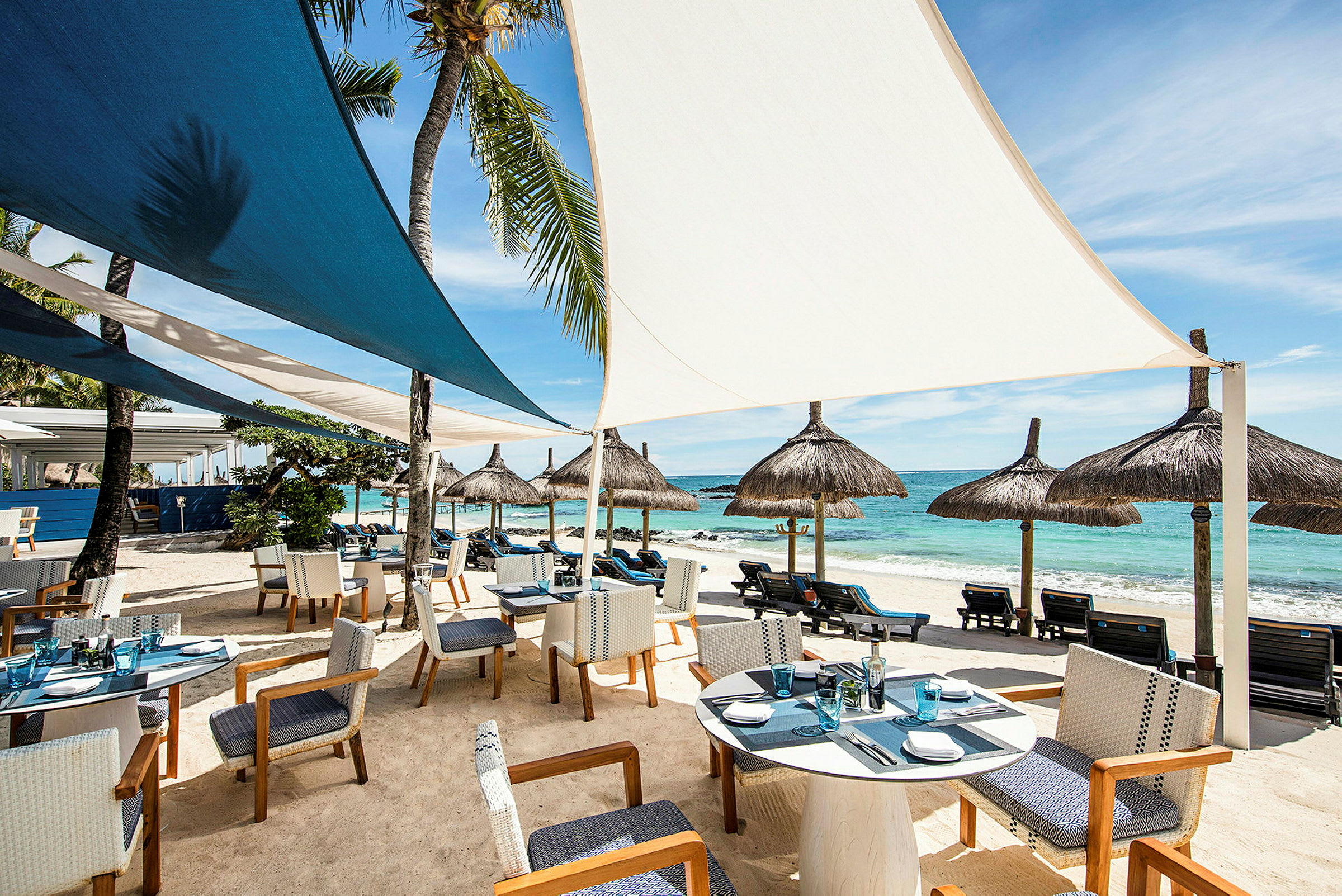 Restaurang vid stranden med sittplatser och parasoller. (AI-genererad text)