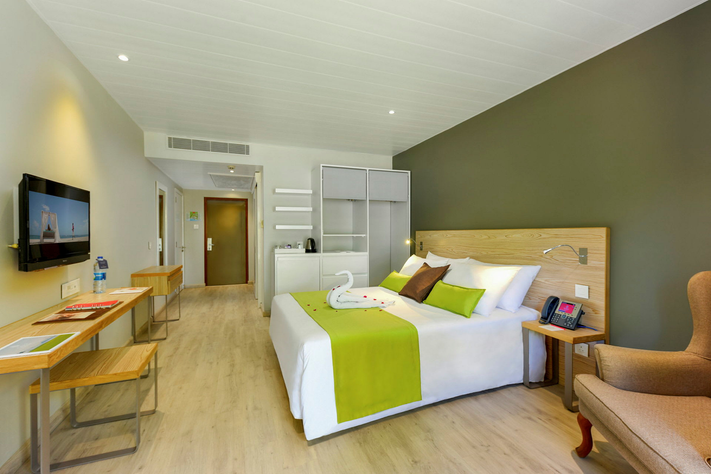 Hotellrum med säng, sittplats och skrivbord. (AI-genererad text)