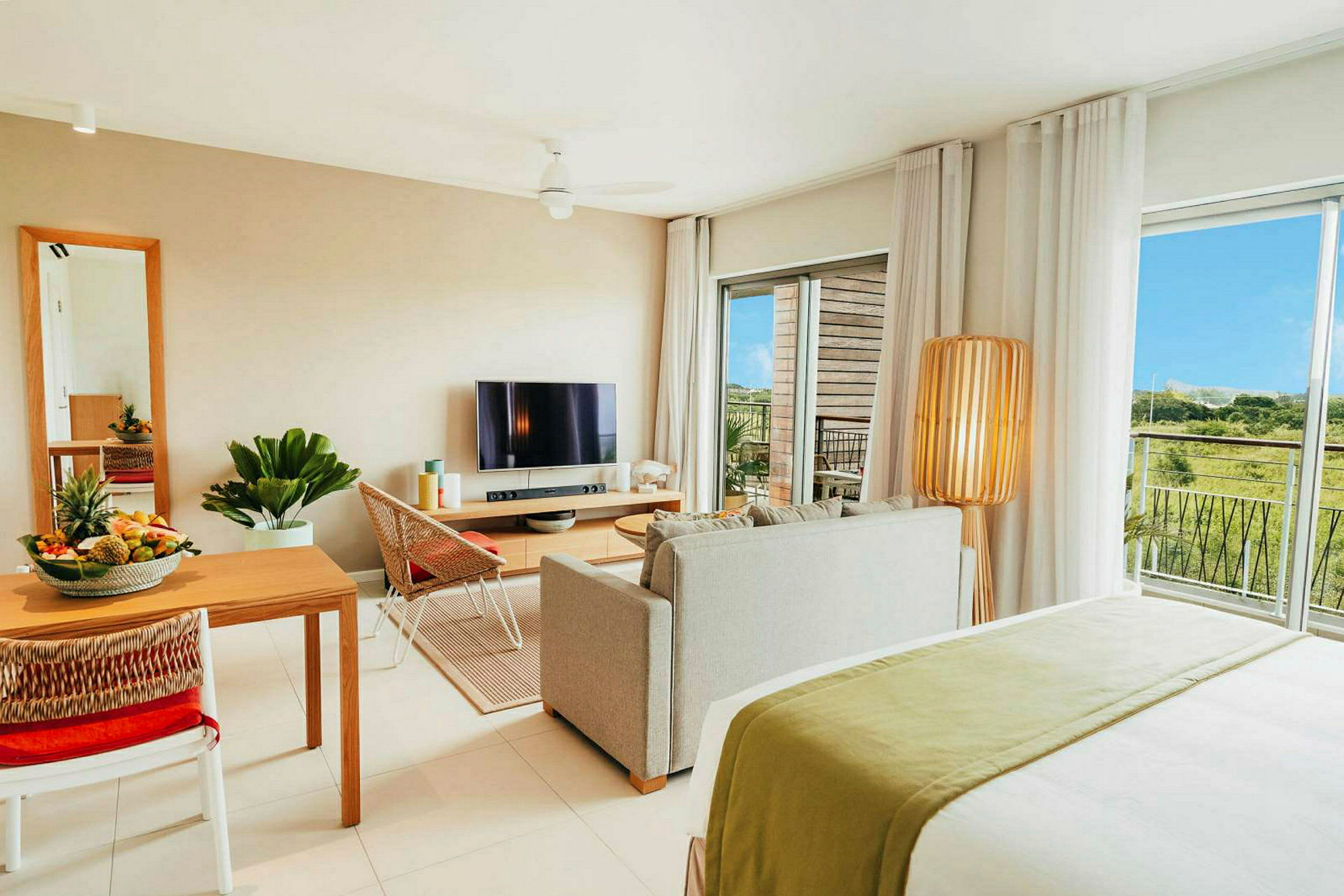 Modernt inredd lägenhet med vardagsrum, matplats, TV och utsikt över grönska. (AI-genererad text)