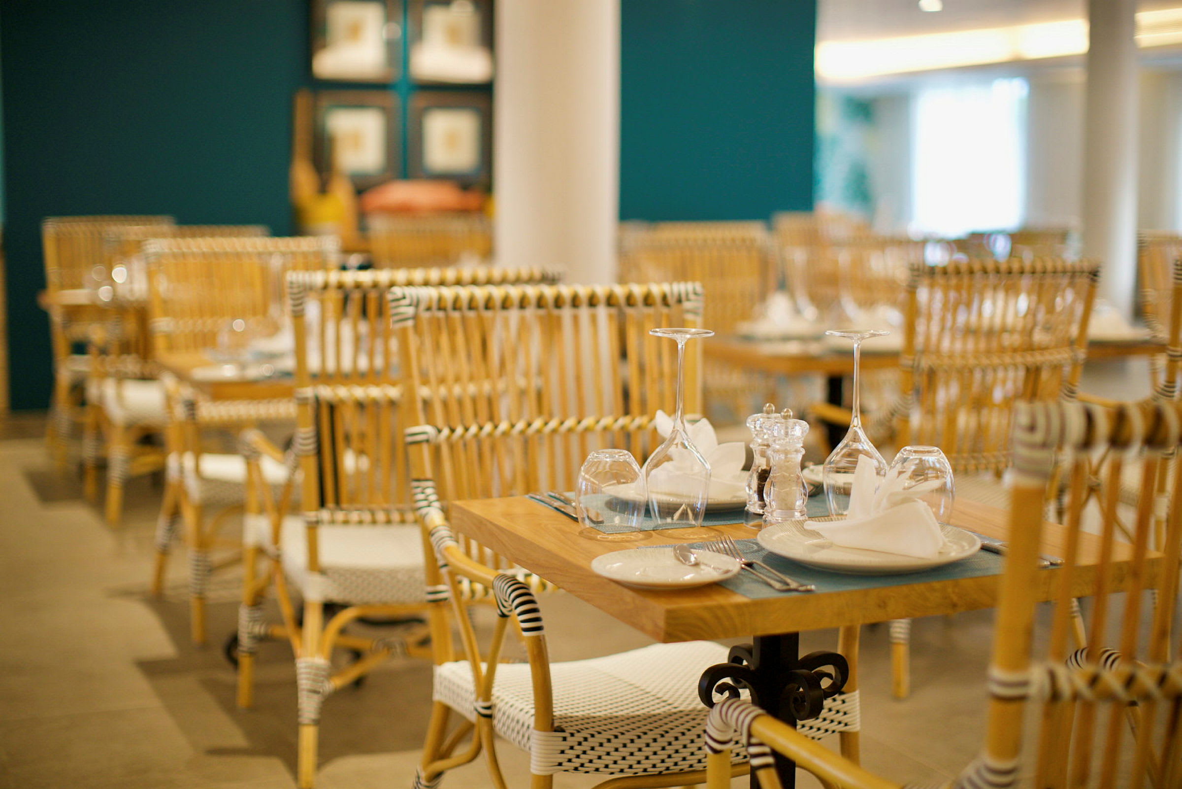 En restaurang med dukade bord och stolar i trä. (AI-genererad text)