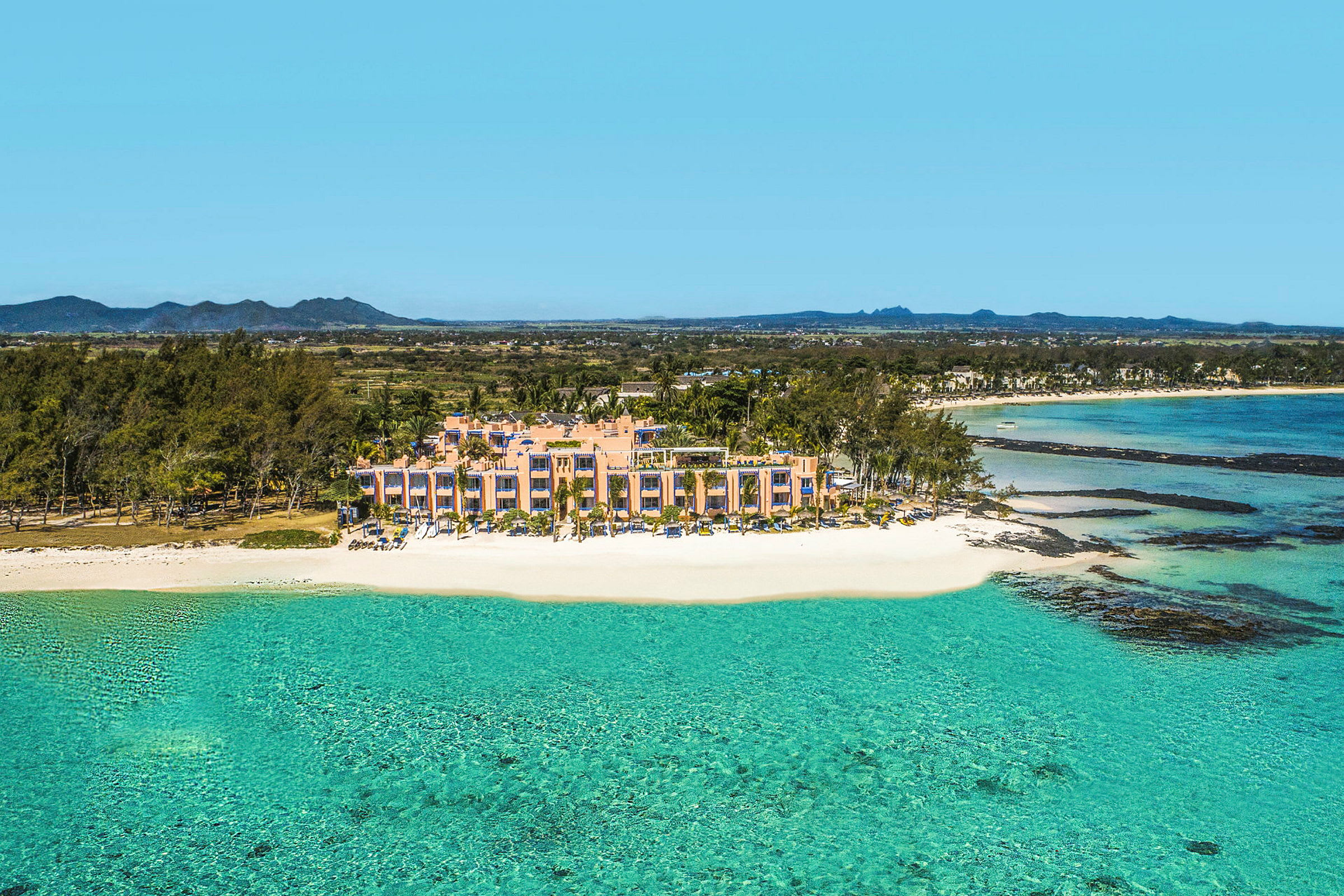 Strandnära resort vid klart blågrönt vatten. (AI-genererad text)