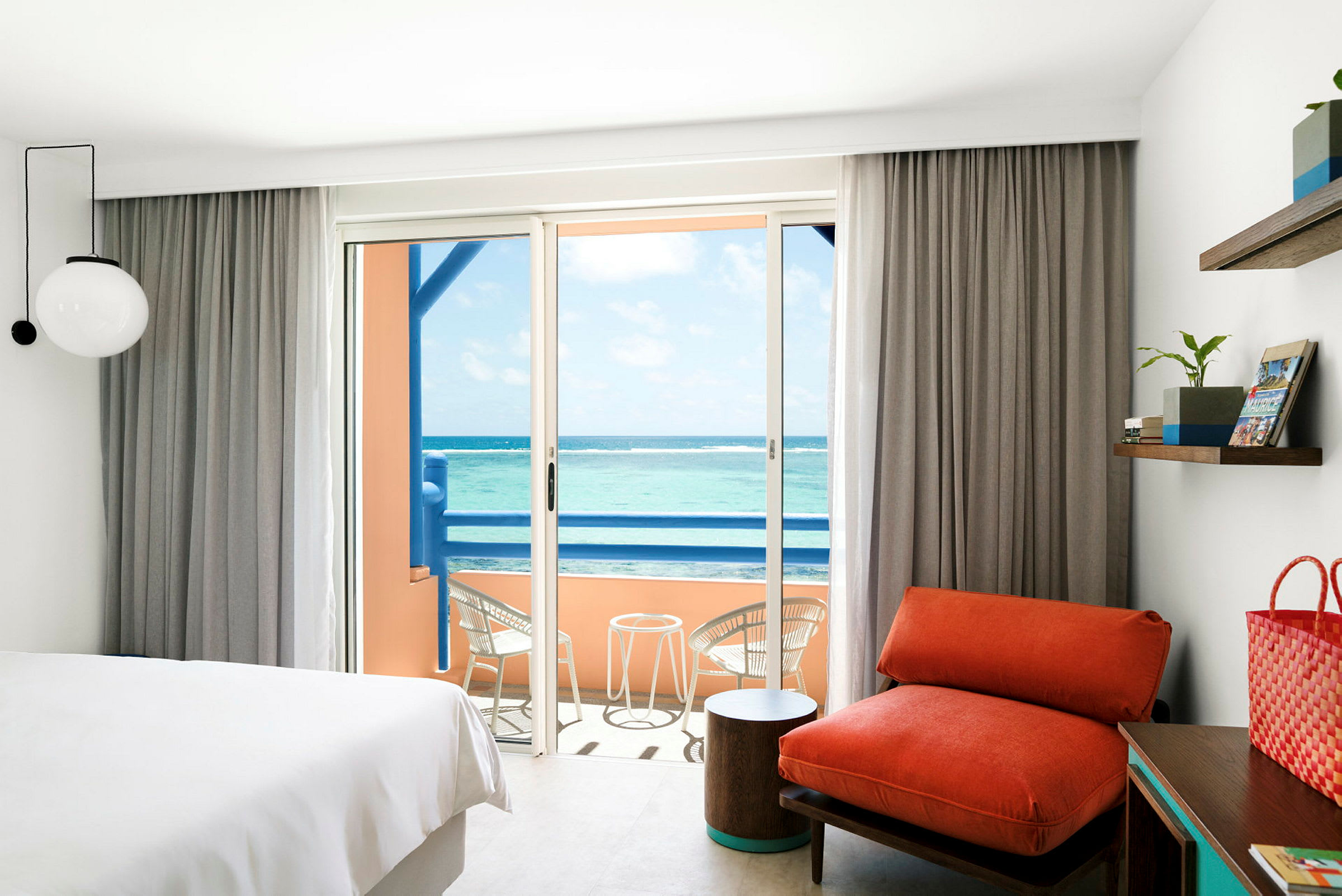 Ett hotellrum med en balkong som har utsikt över havet. (AI-genererad text)
