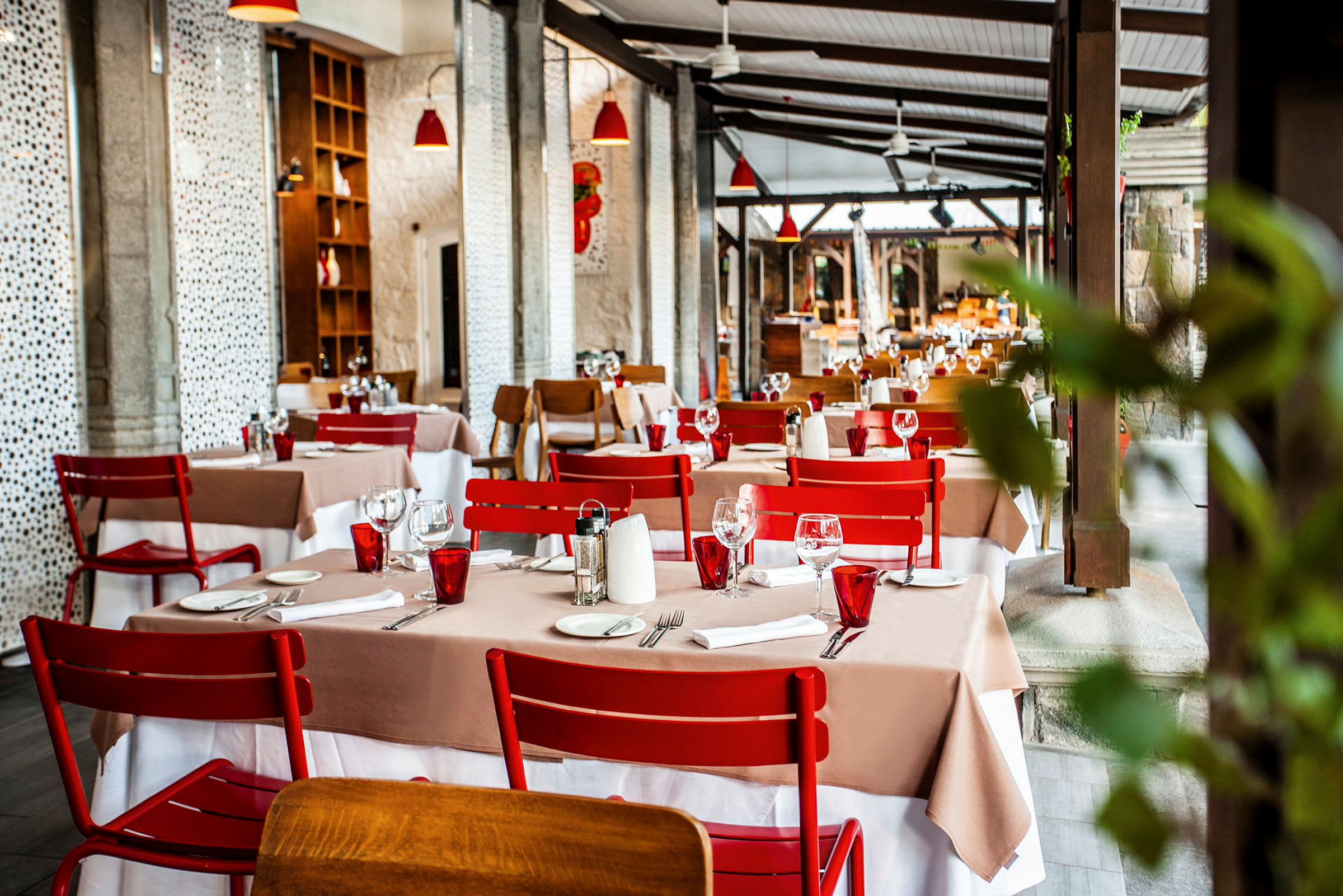 Restaurang med dukade bord och röda stolar. (AI-genererad text)
